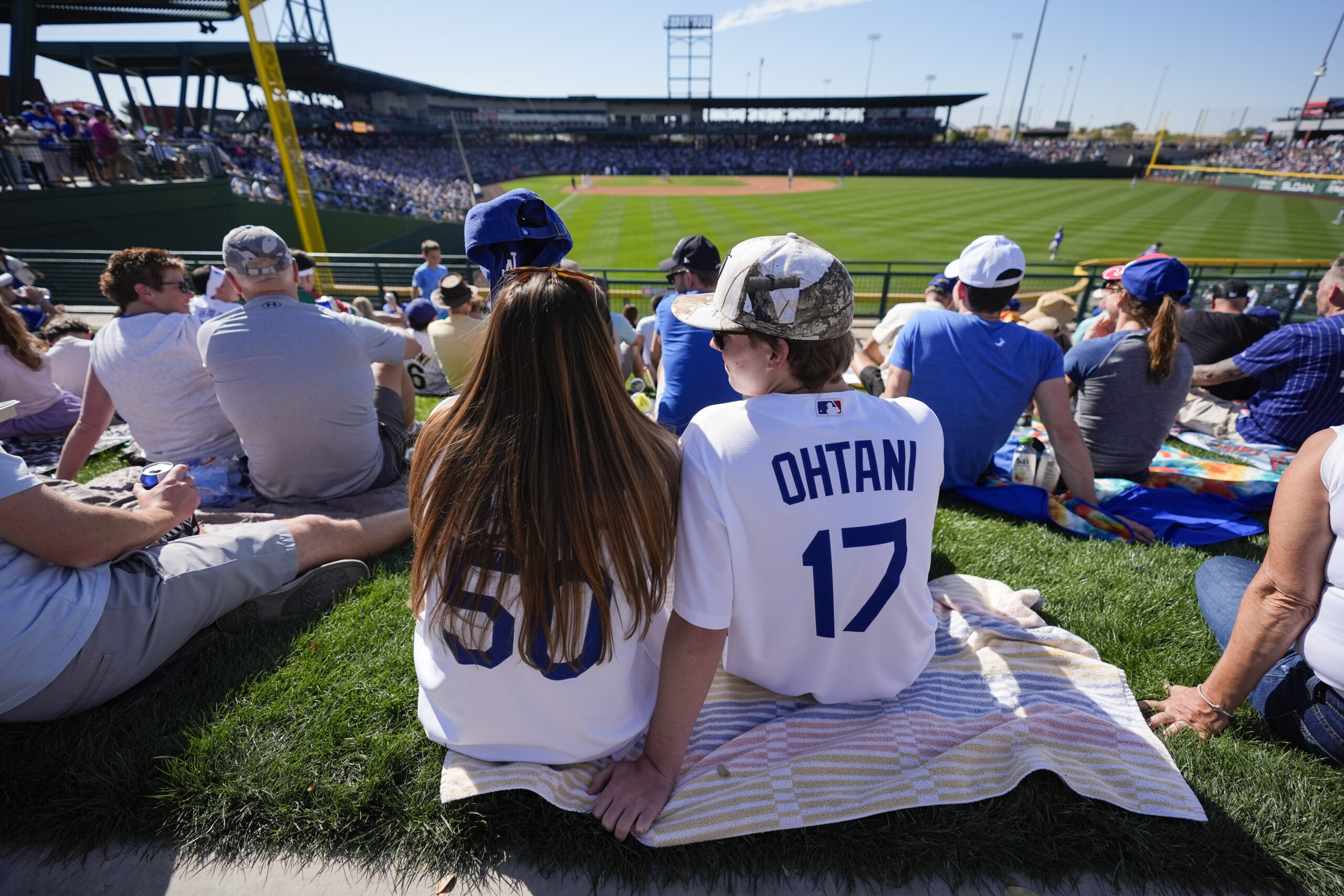 Fans watch from the outfield during the fourth inning of...