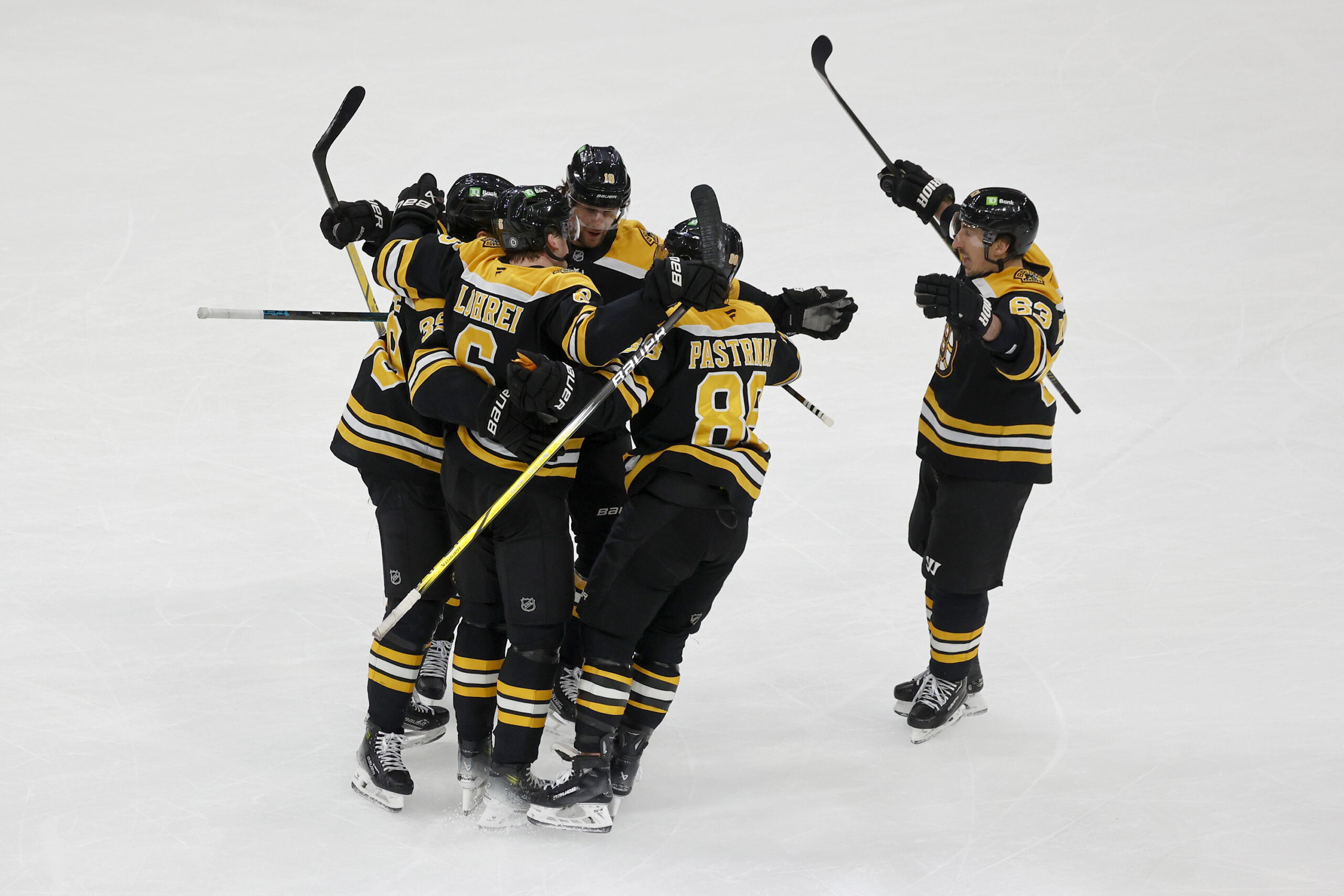 Boston Bruins left wing Brad Marchand, right, joins teammates in...