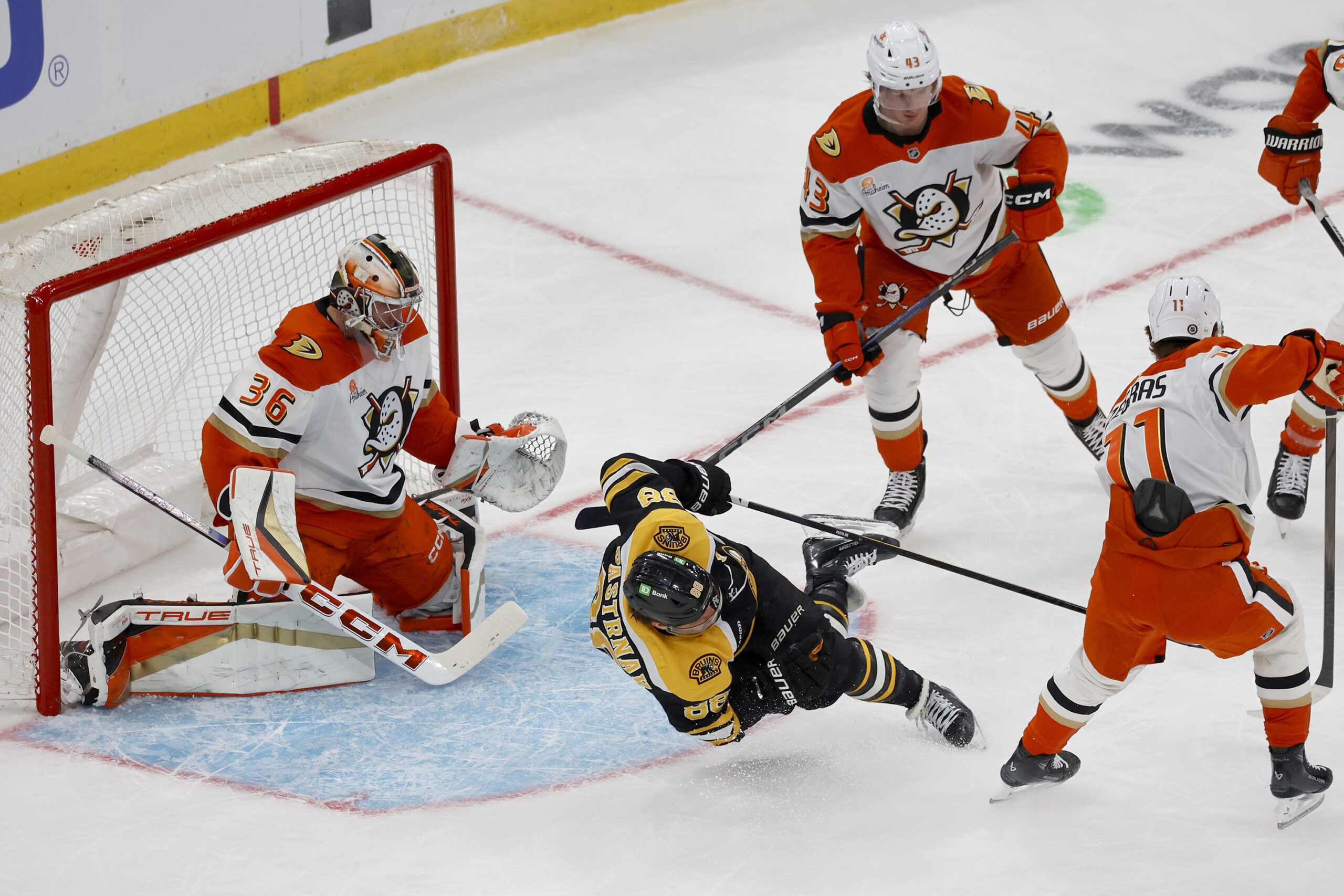 Boston Bruins right wing David Pastrnak (88) is tripped up...