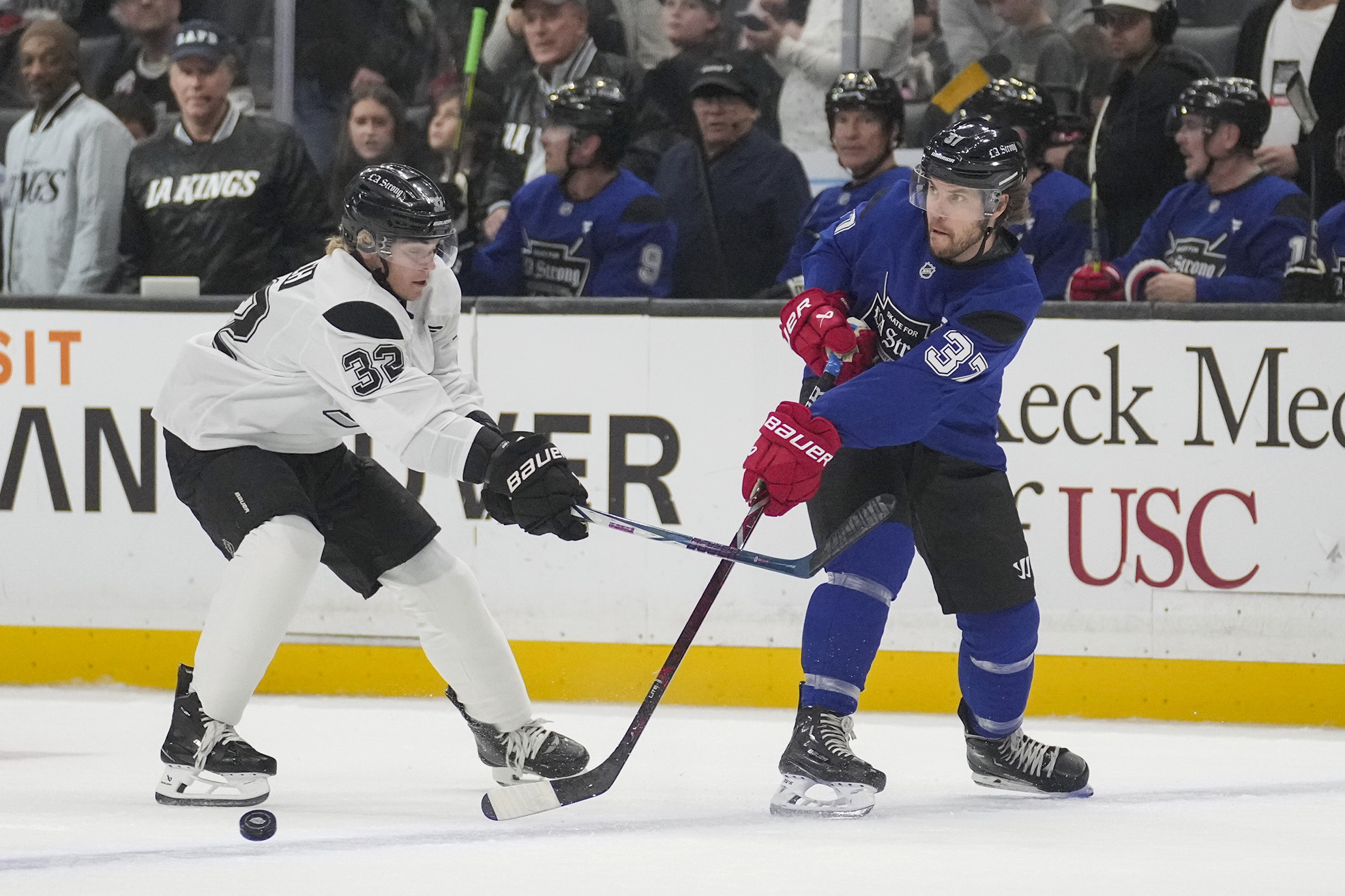 Team Blue player actor Taylor Kitsch passes the puck against...