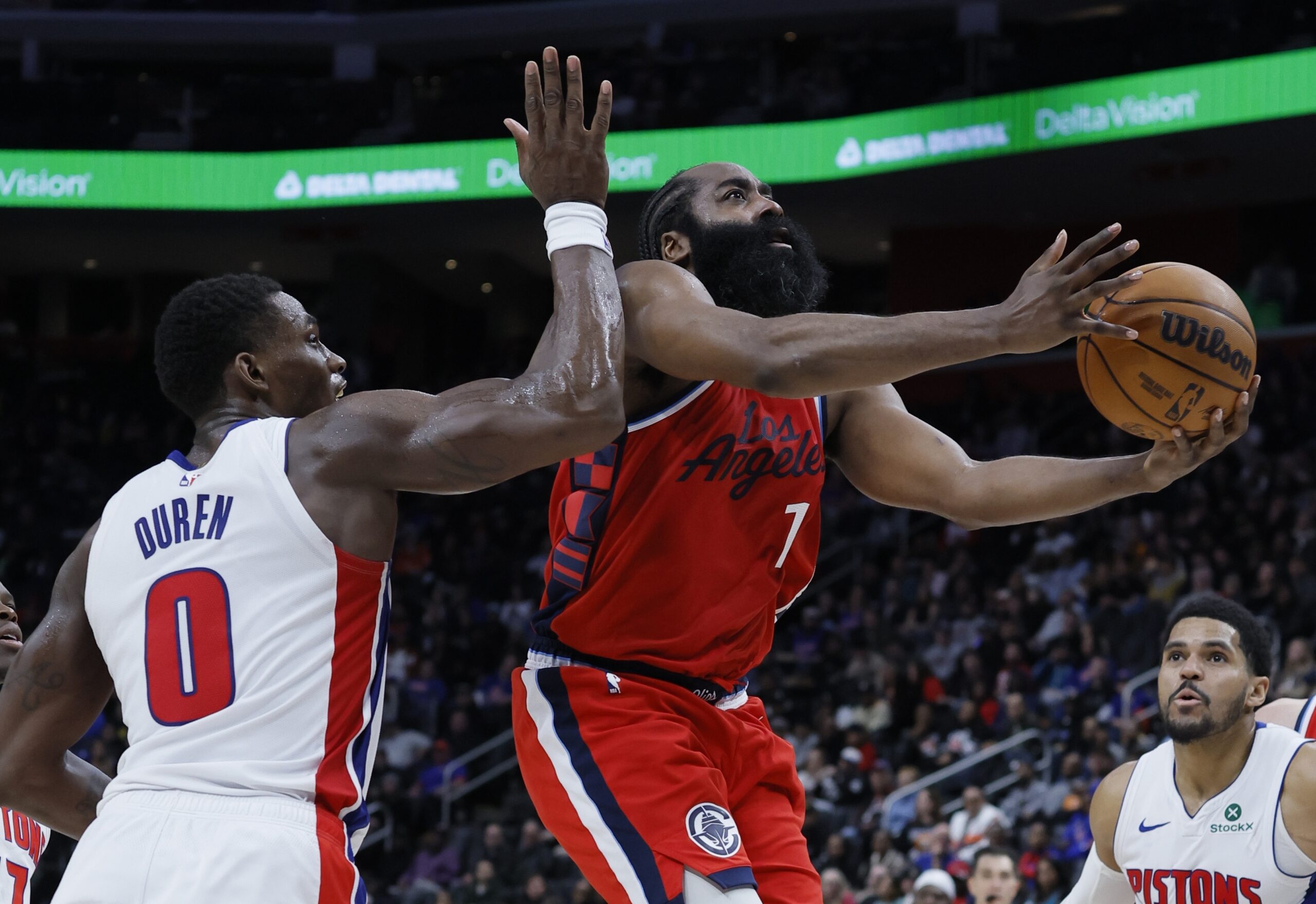 Clippers guard James Harden gets to the basket past Detroit...