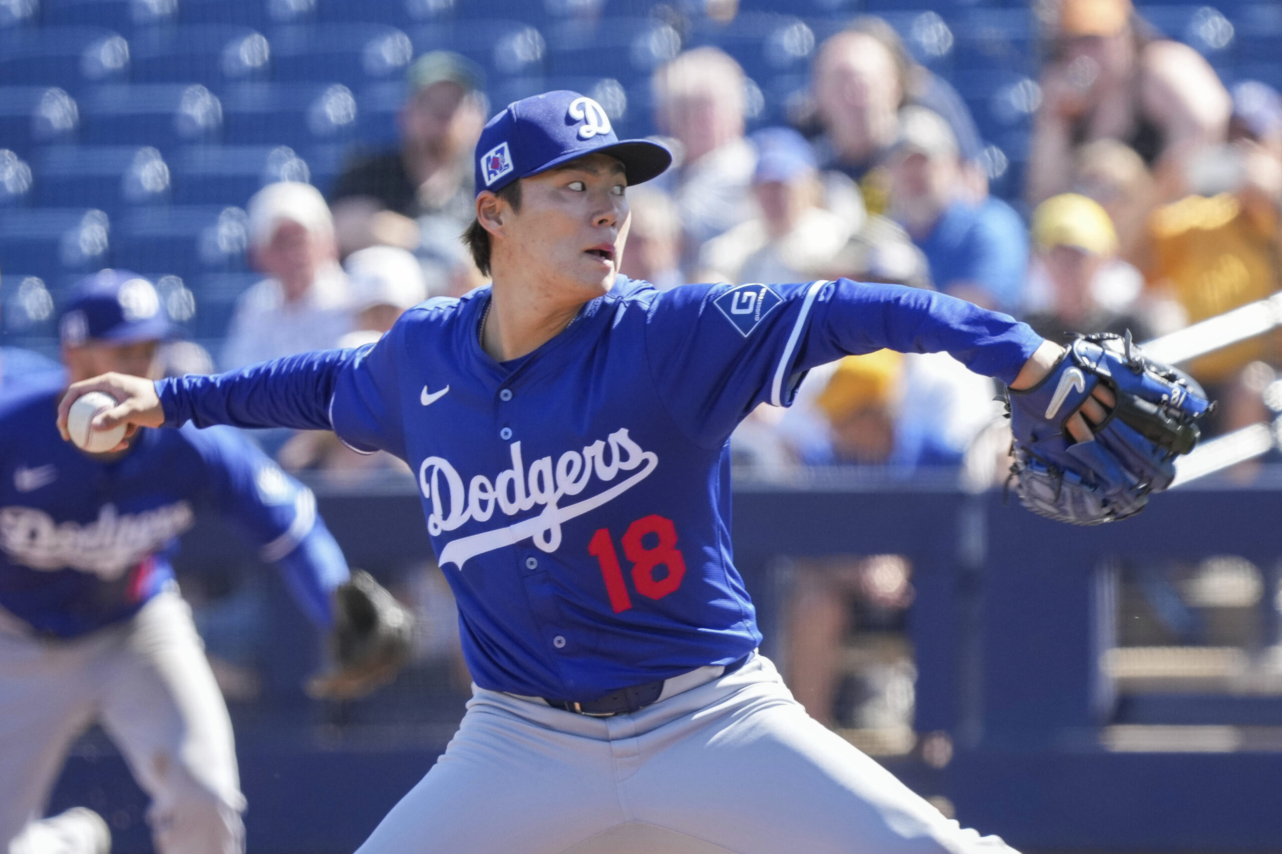 Dodgers starting pitcher Yoshinobu Yamamoto throws to the plate during...