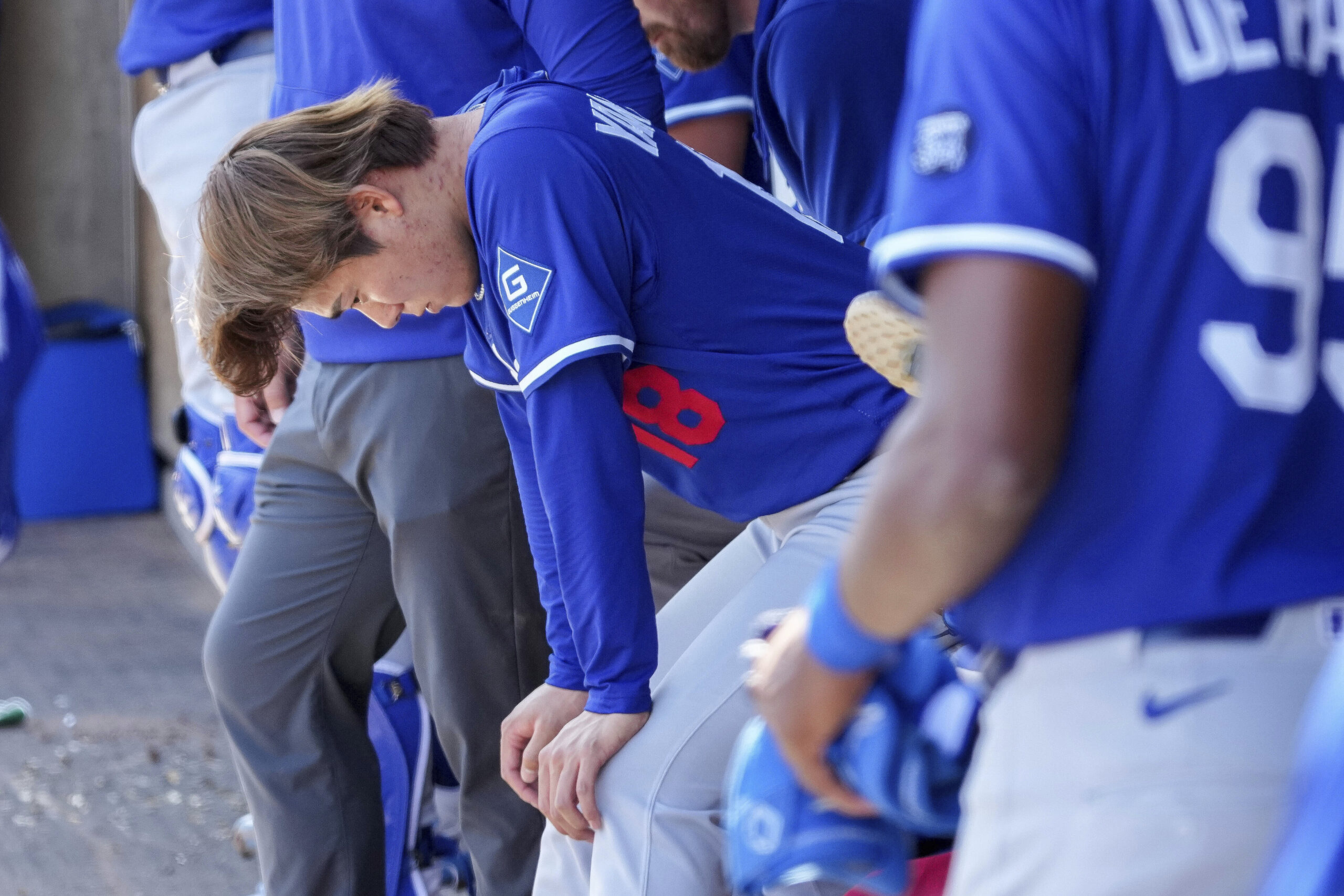 Dodgers pitcher Yoshinobu Yamamoto (18) rests in the dugout after...