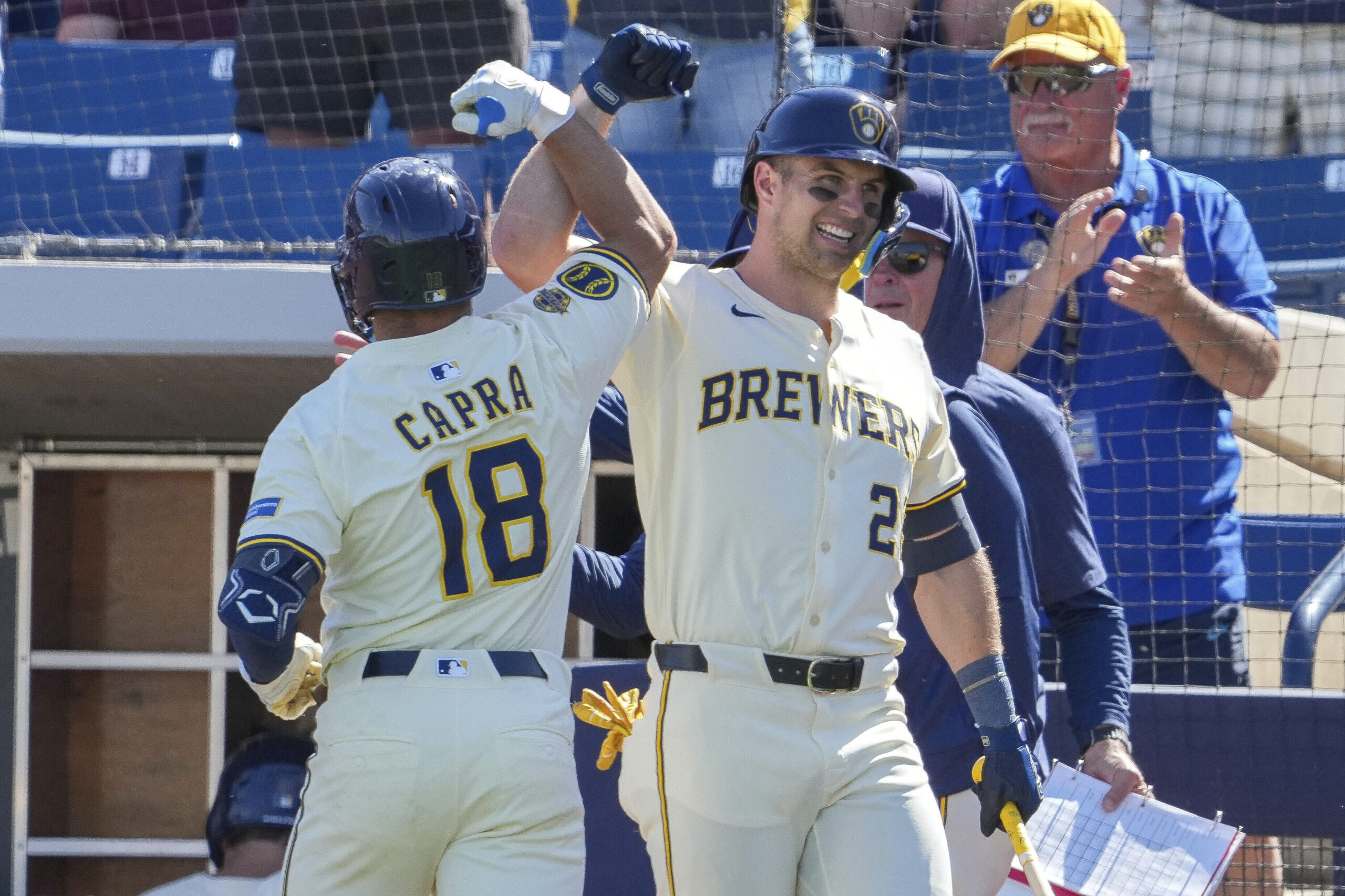 The Milwaukee Brewers’ Vinny Capra (18) gets a forearm bump...