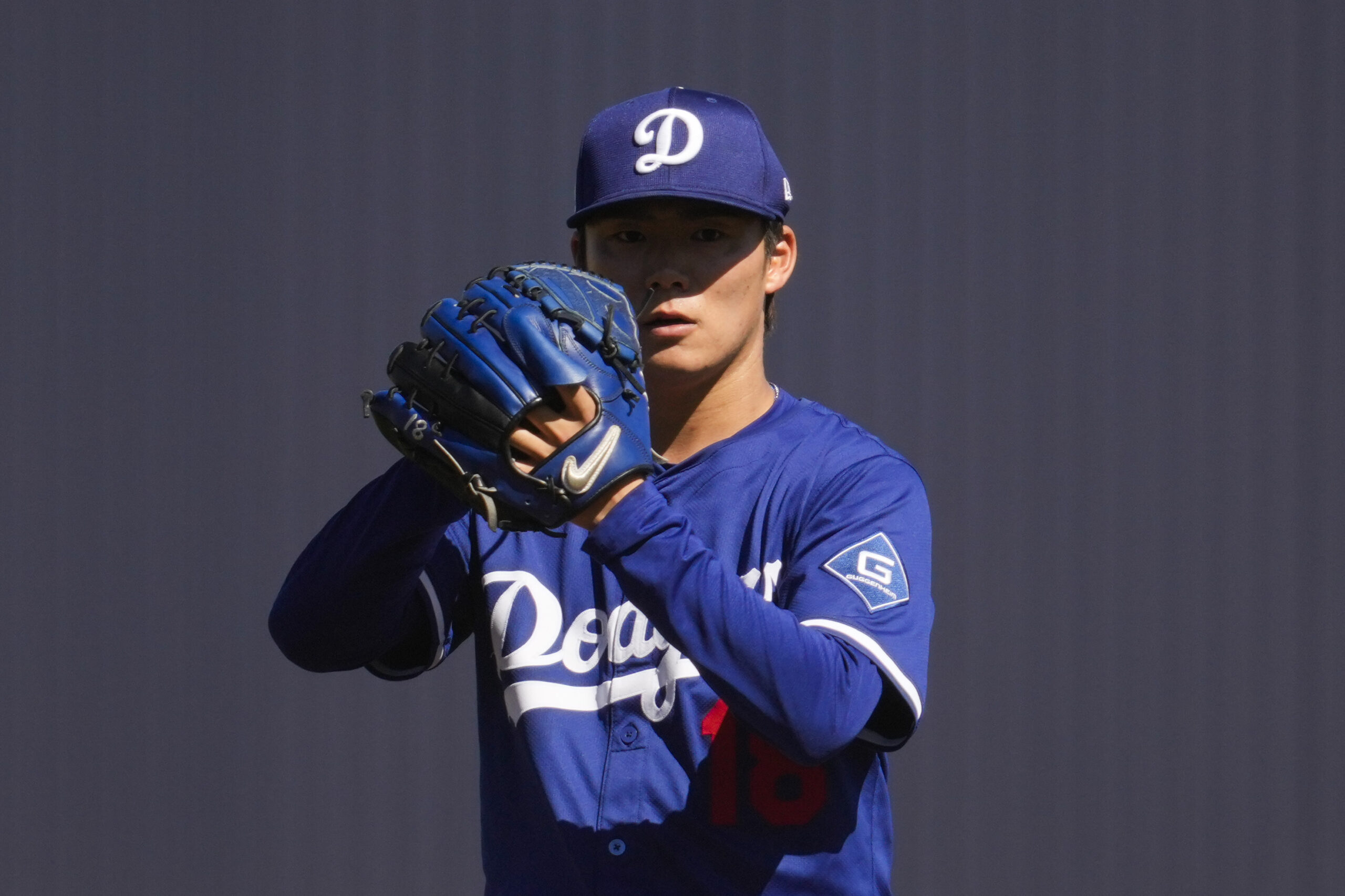 Dodgers starting pitcher Yoshinobu Yamamoto stands on the mound during...