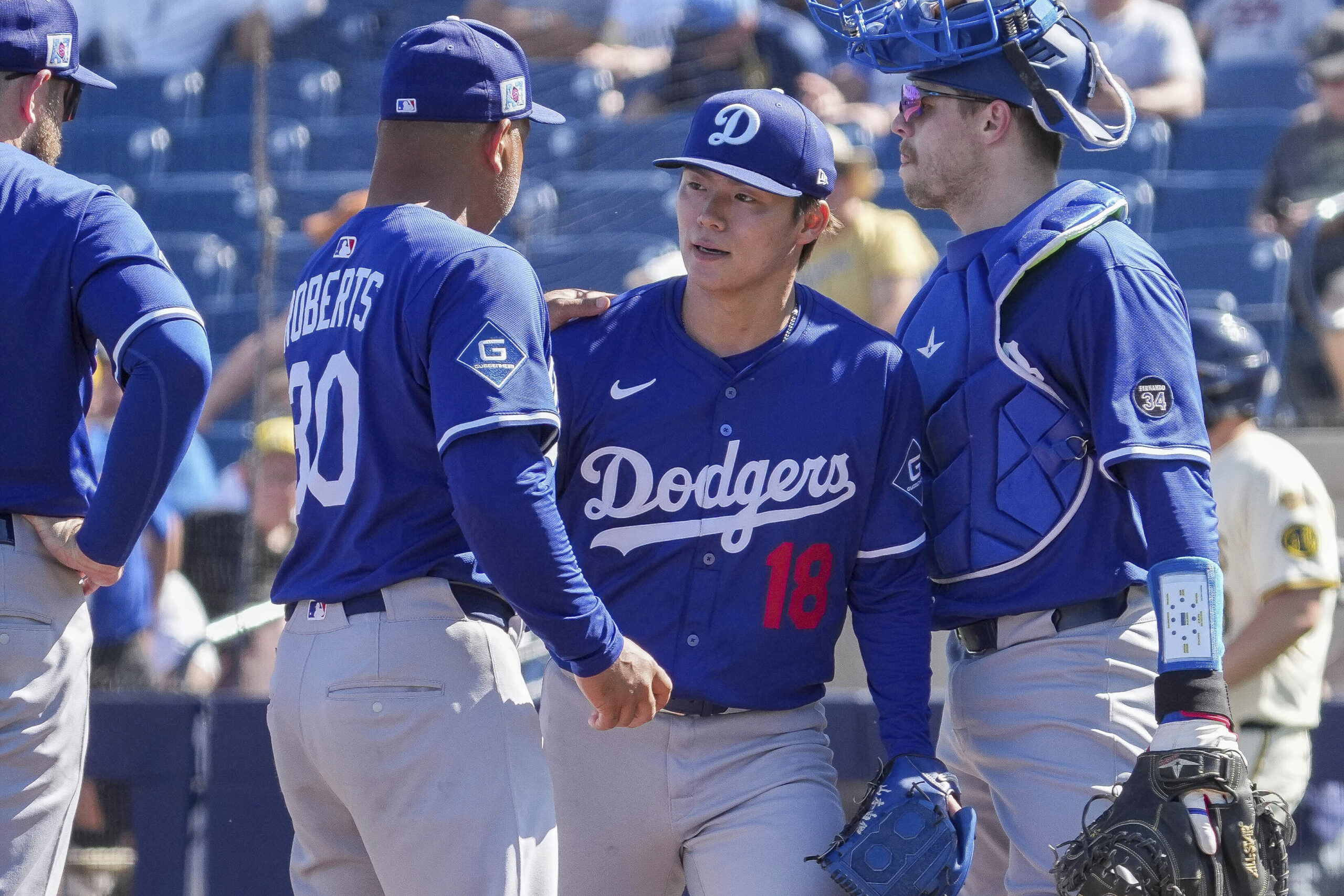 Dodgers pitcher Yoshinobu Yamamoto (18), gets a pat on the...