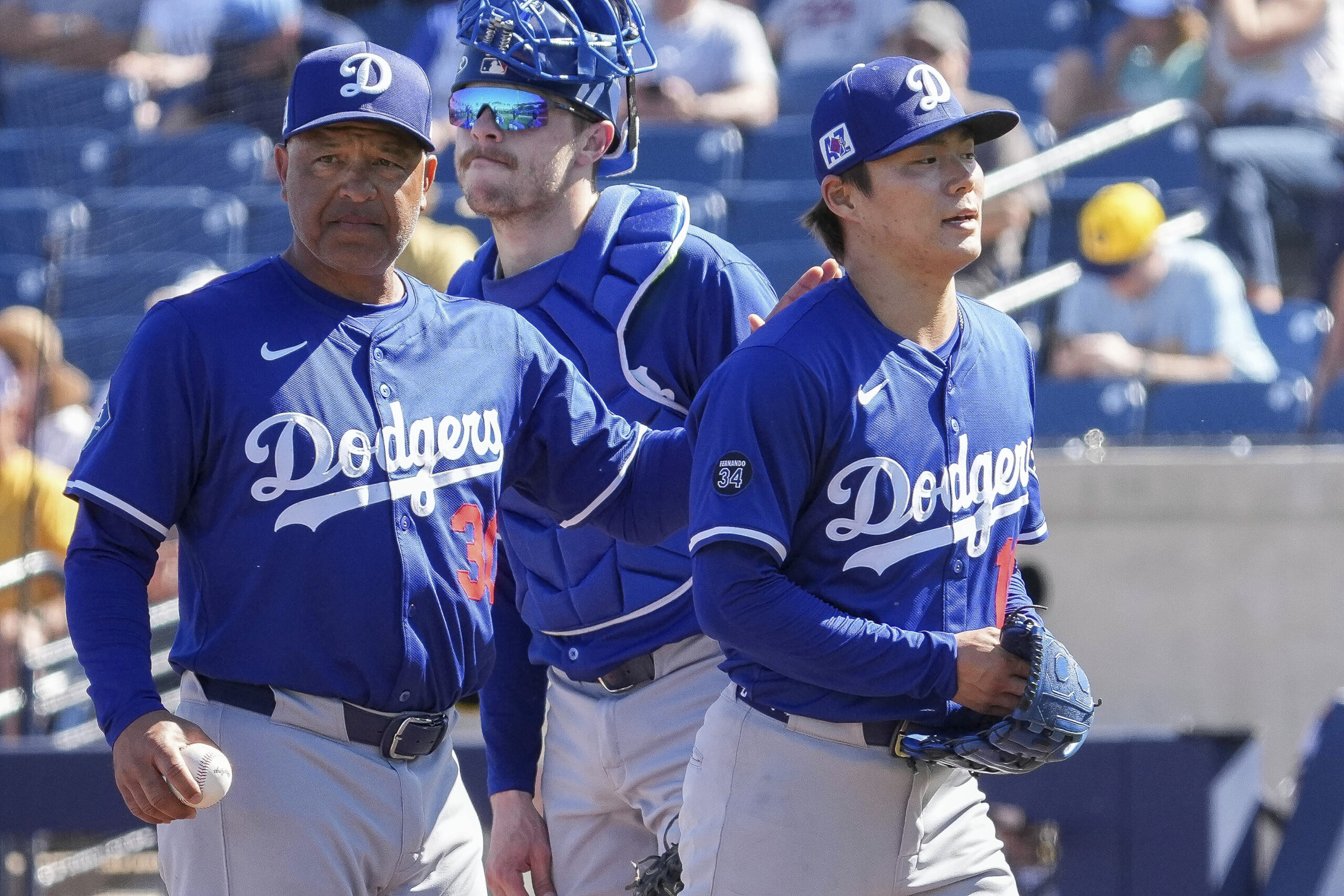 Dodgers pitcher Yoshinobu Yamamoto (18), gets a pat on the...