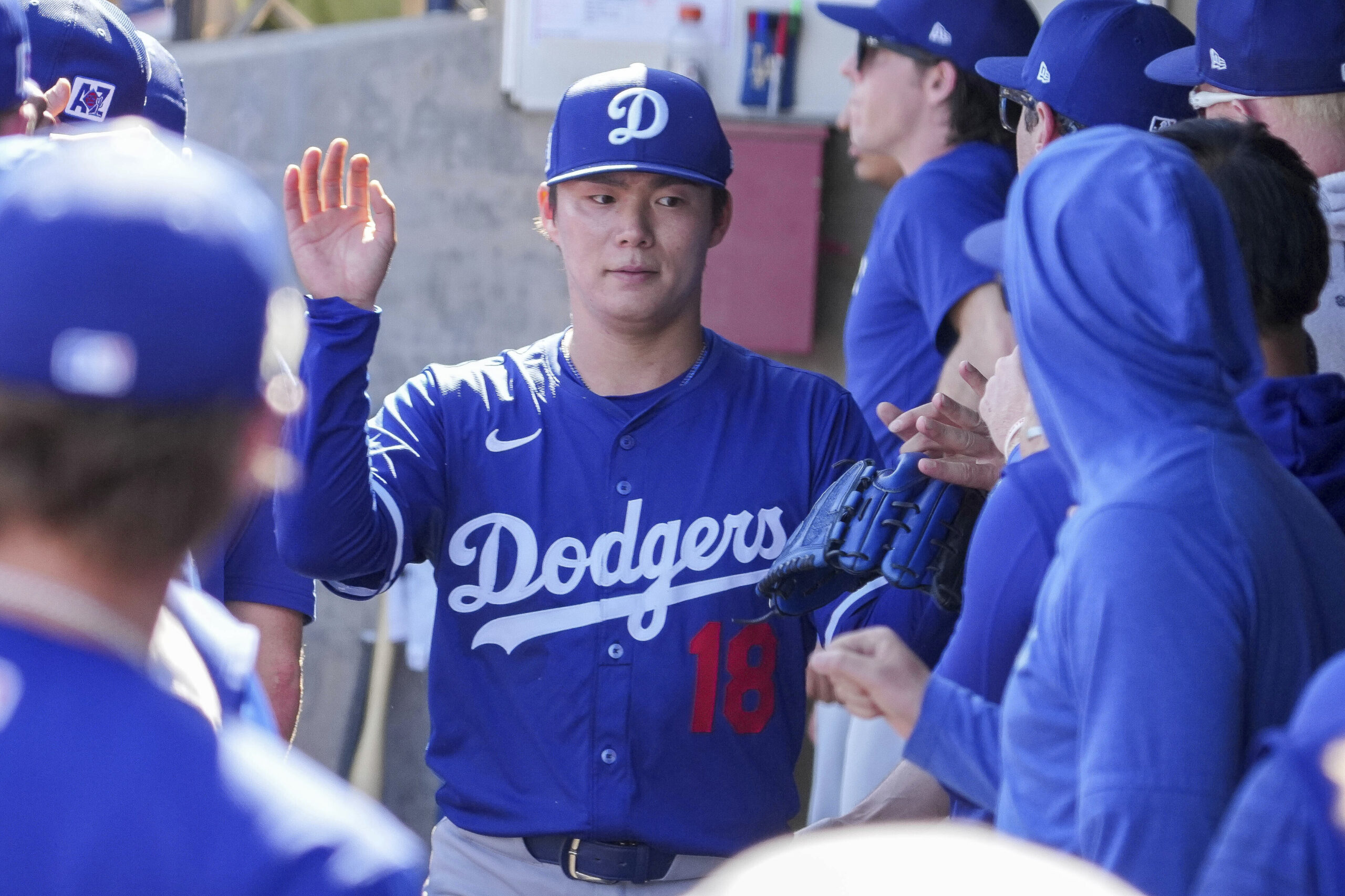 Dodgers pitcher Yoshinobu Yamamoto (18), is greeted by teammates after...