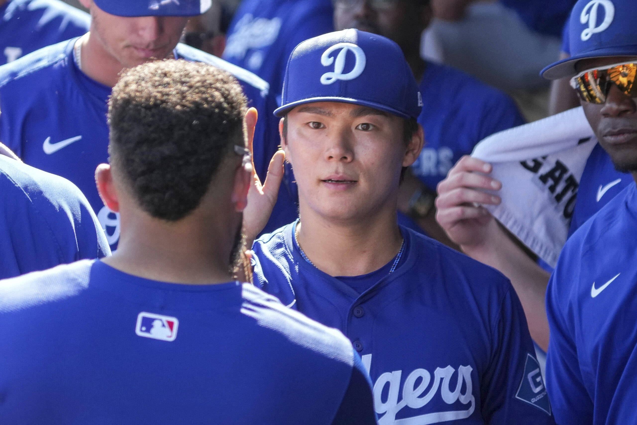 Dodgers pitcher Yoshinobu Yamamoto is greeted by teammates after pitching...