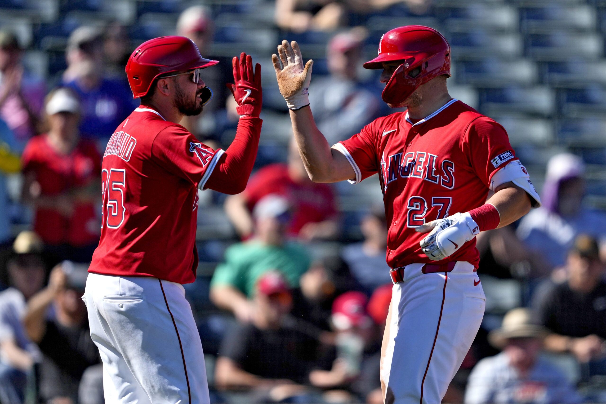 Angels star Mike Trout, right, high-fives teammate Travis d’Arnaud after...