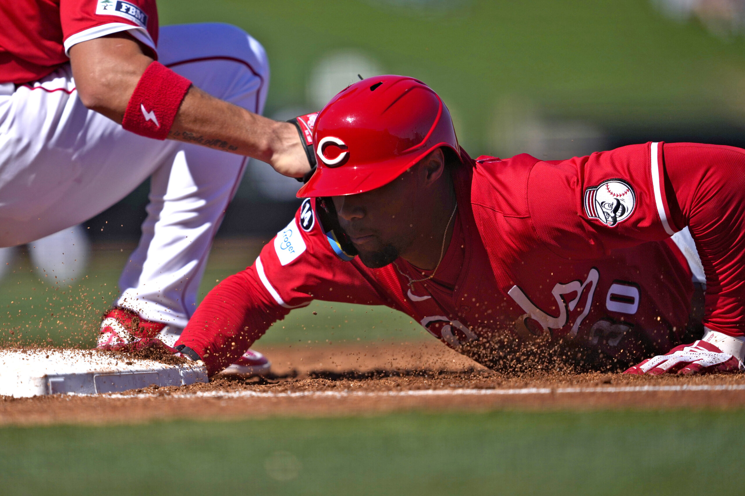 The Cincinnati Reds’ Will Benson dives back safely on a...