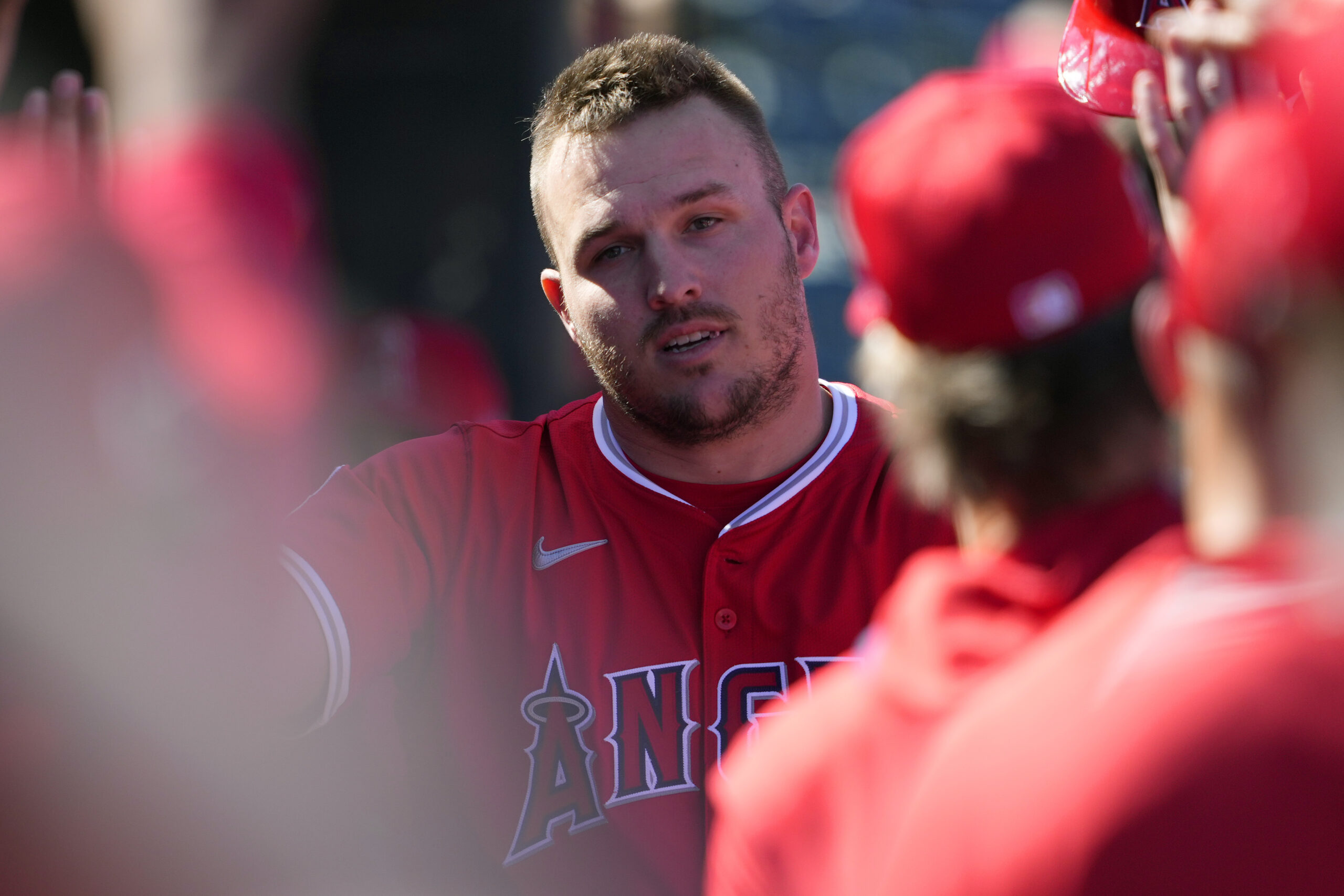 Angels star Mike Trout is greeted in the dugout after...