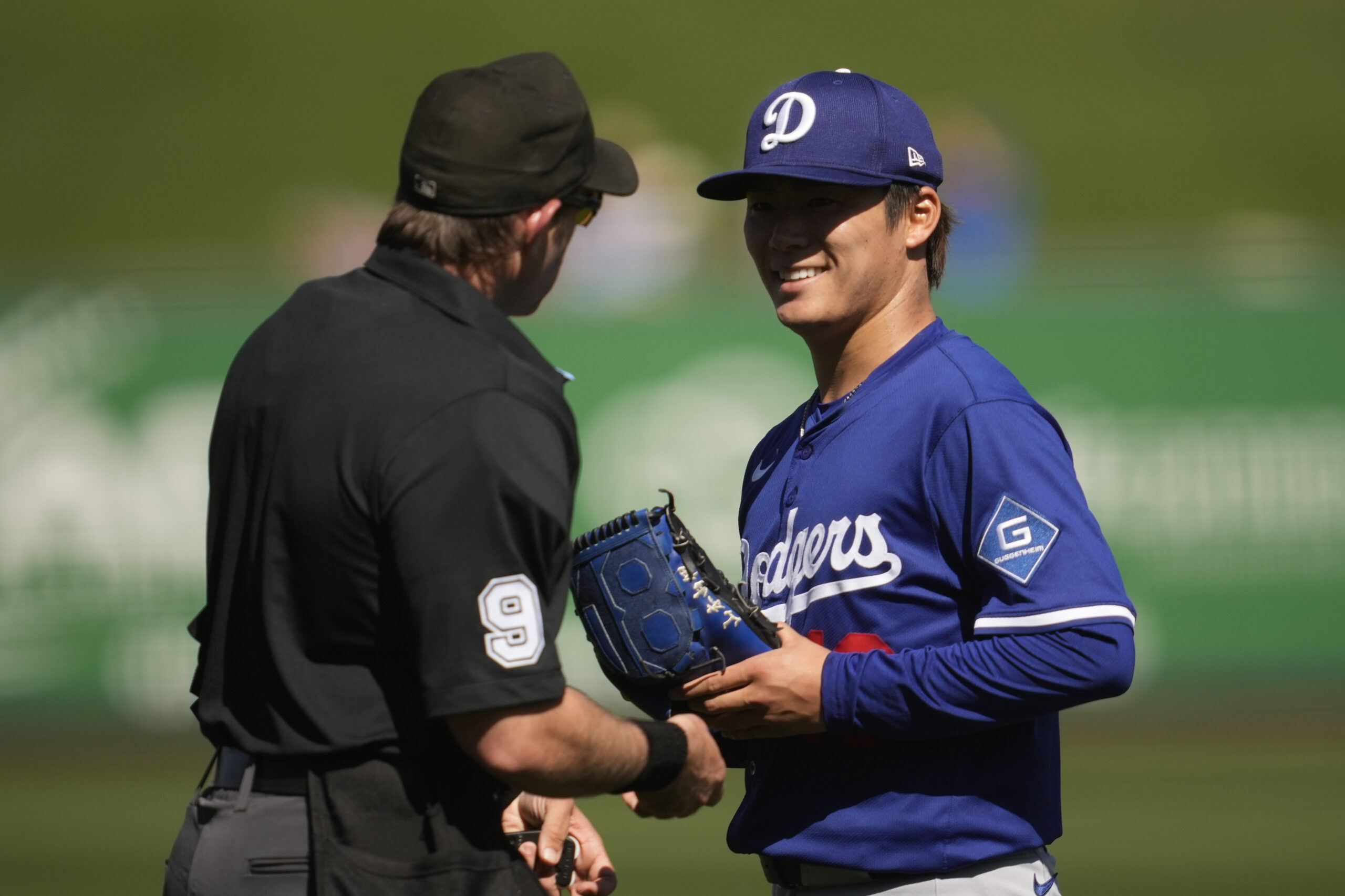 Dodgers starting pitcher Yoshinobu Yamamoto is inspected by umpire Alex...