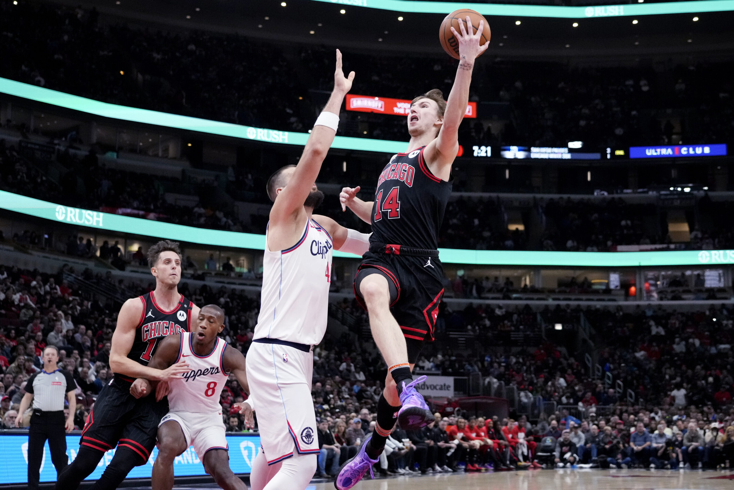 Chicago Bulls forward Matas Buzelis, right, drives to the basket...