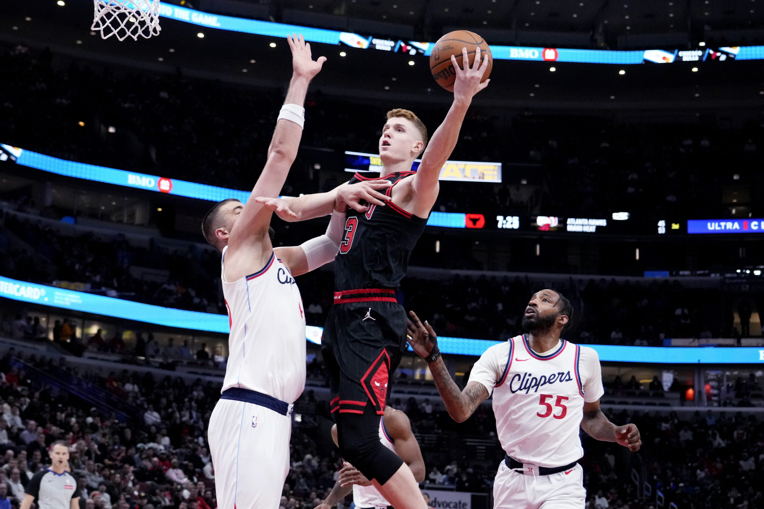 Chicago Bulls guard Kevin Huerter, center, drives to the basket...