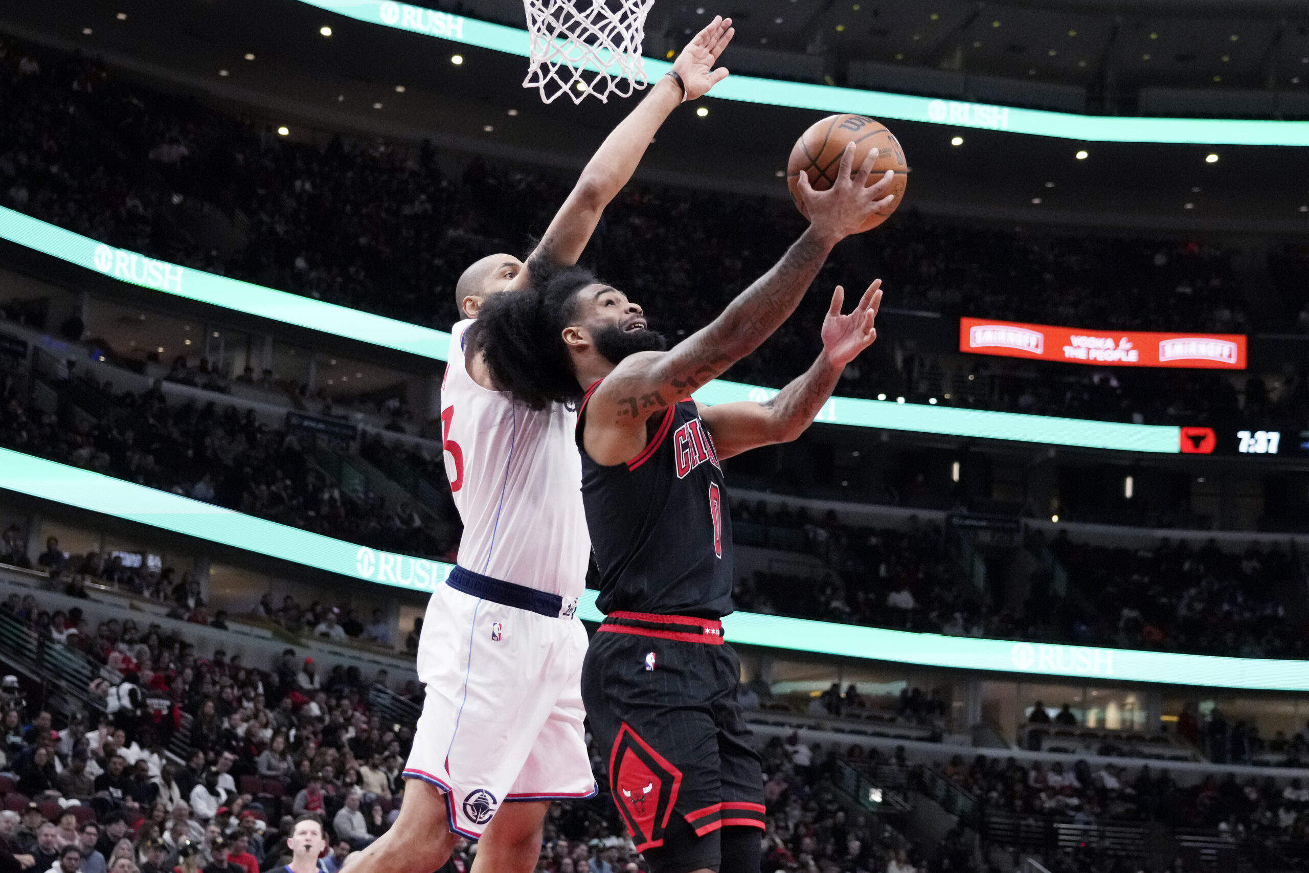 Chicago Bulls guard Coby White, right, drives to the basket...