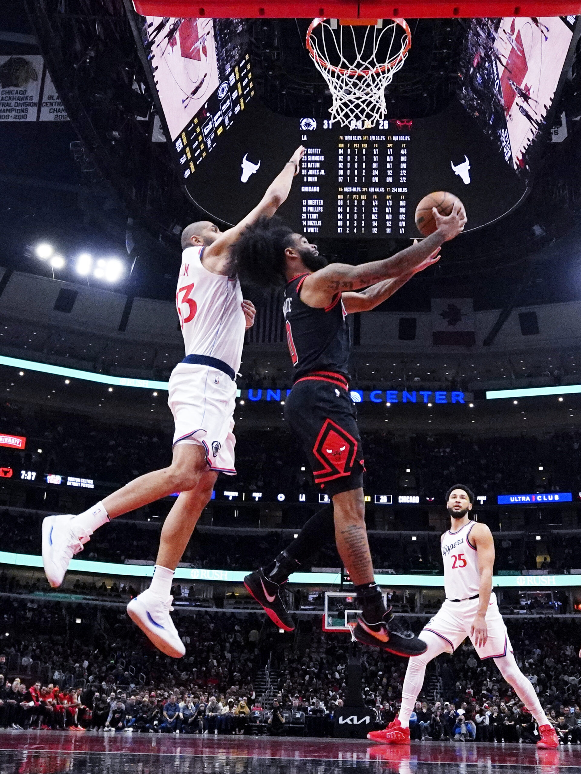 Chicago Bulls guard Coby White, right, drives to the basket...