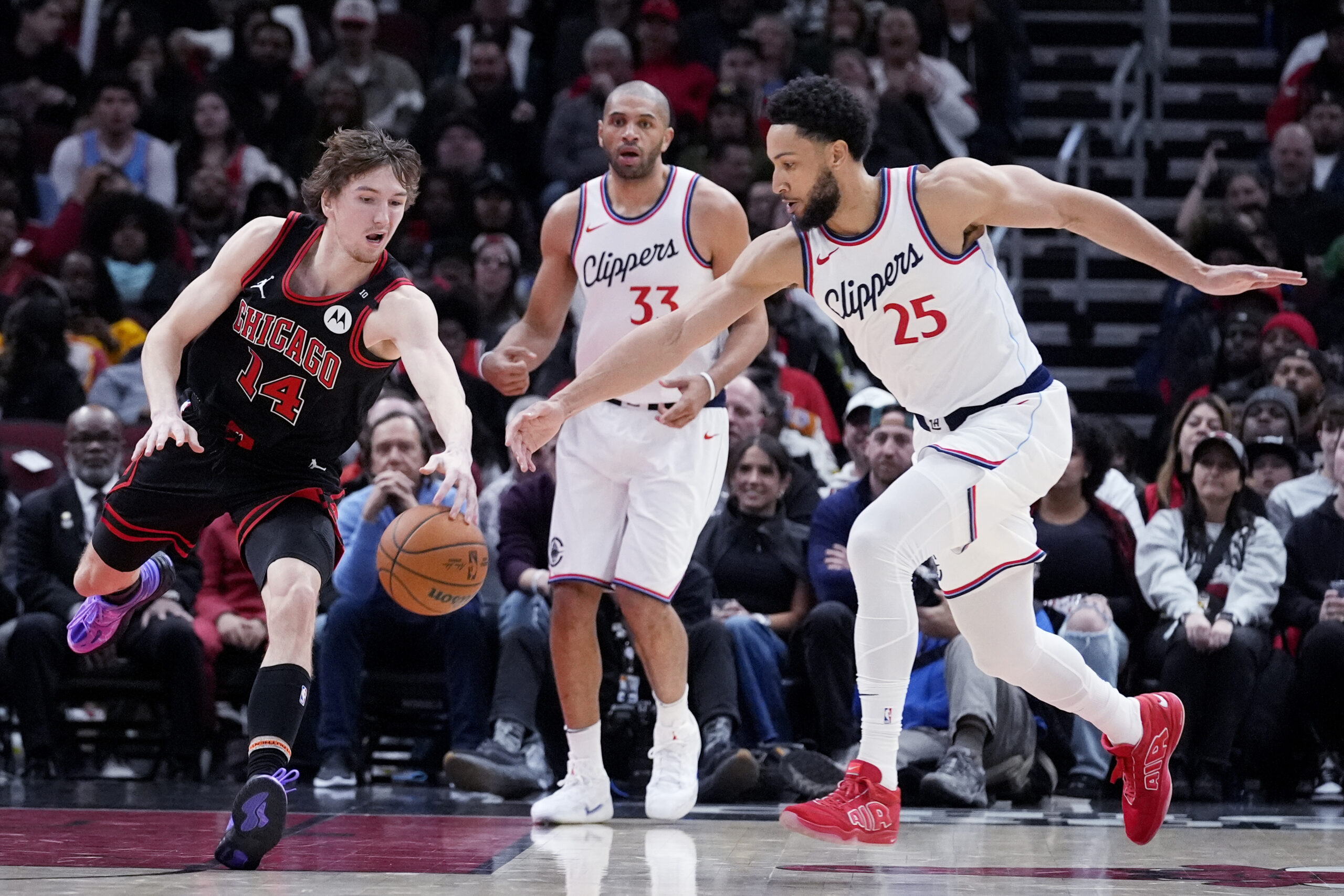 Chicago Bulls forward Matas Buzelis, left, battles for a loose...