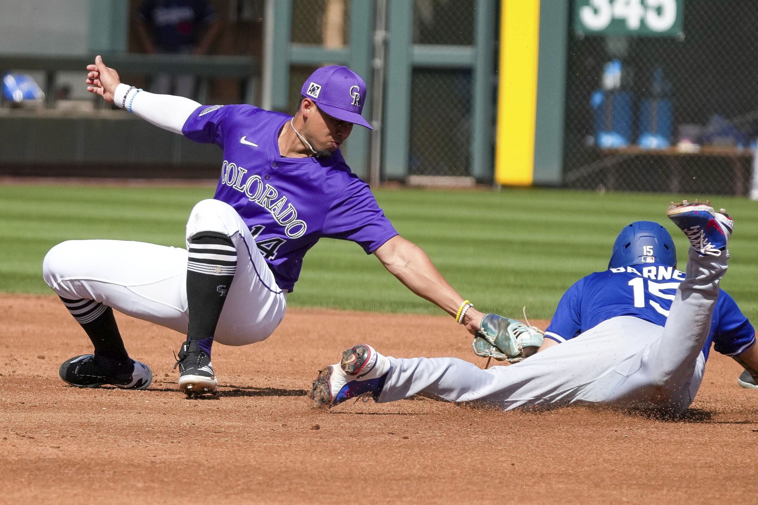 Colorado Rockies shortstop Ezequiel Tovar, left, misses the tag on...