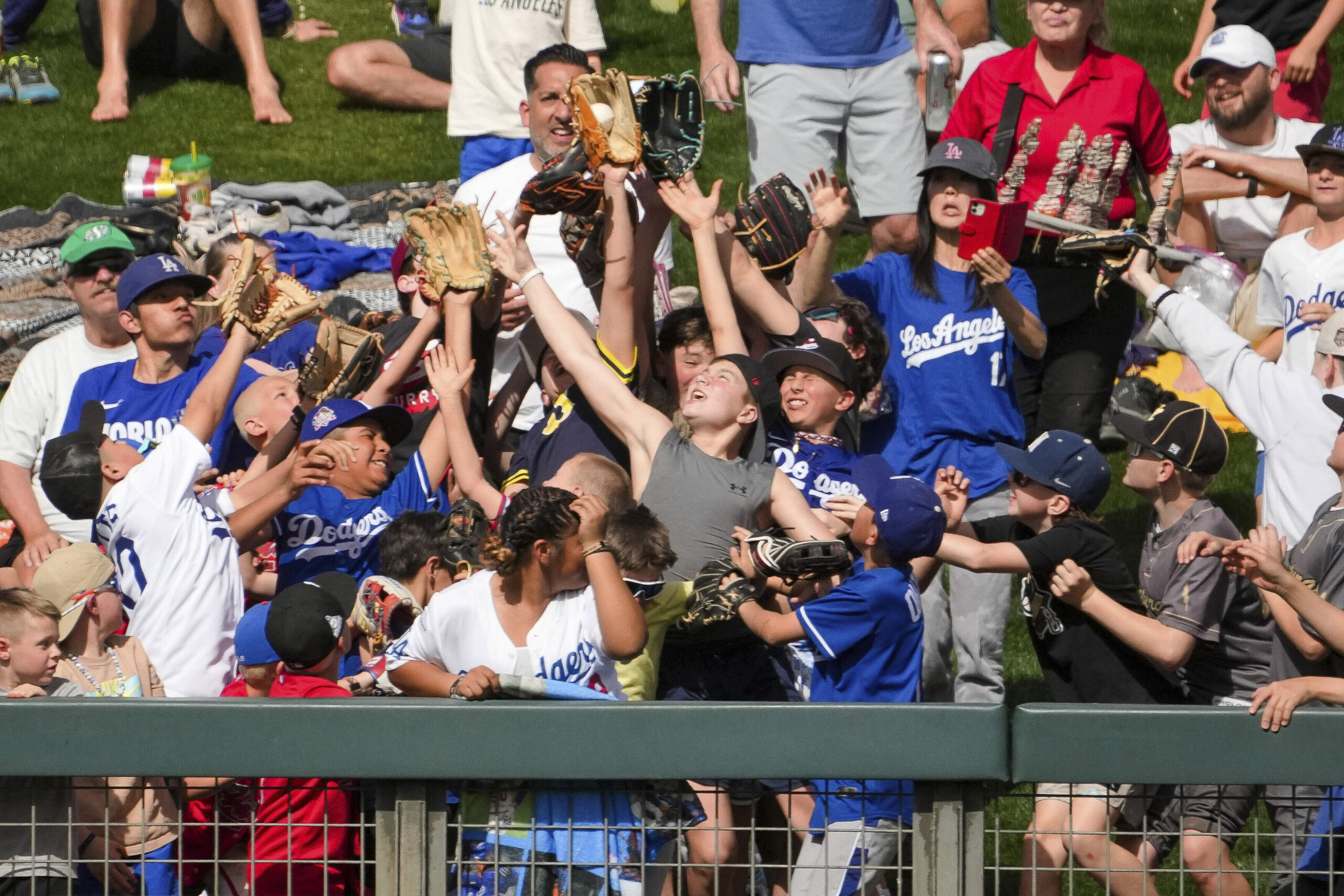 A fan catches a baseball thrown by Dodgers outfielder Tommy...