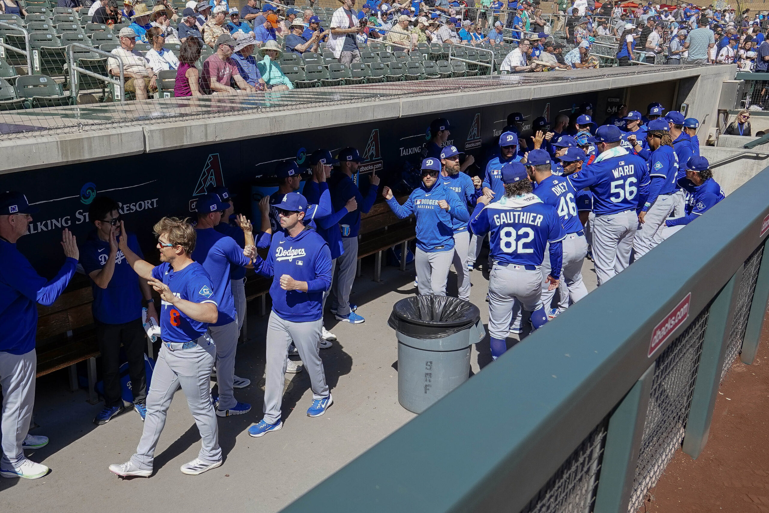 Dodgers players high-five each other before the start of their...