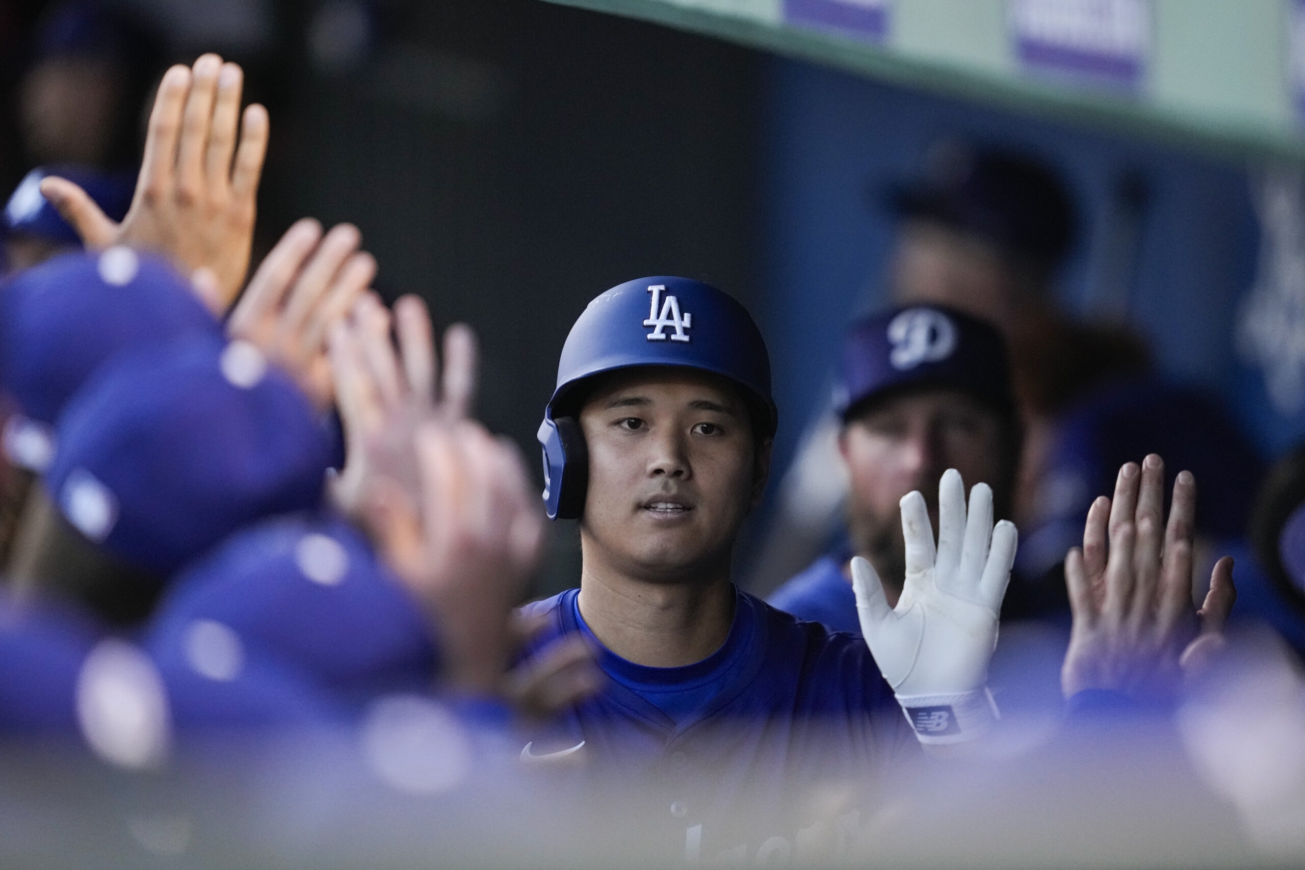 Dodgers designated hitter Shohei Ohtani celebrates with teammates in the...