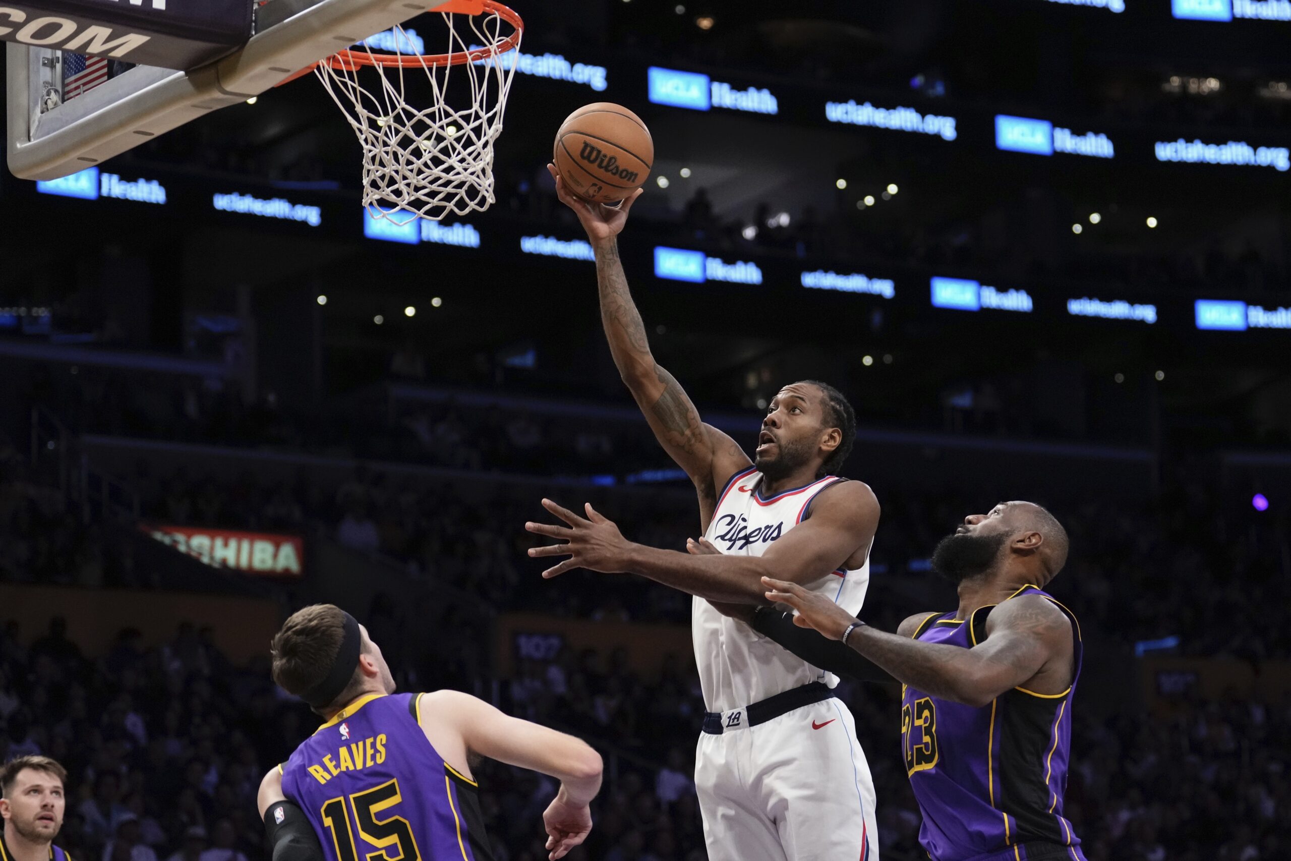 The Clippers’ Kawhi Leonard, second from right, shoots as Lakers...