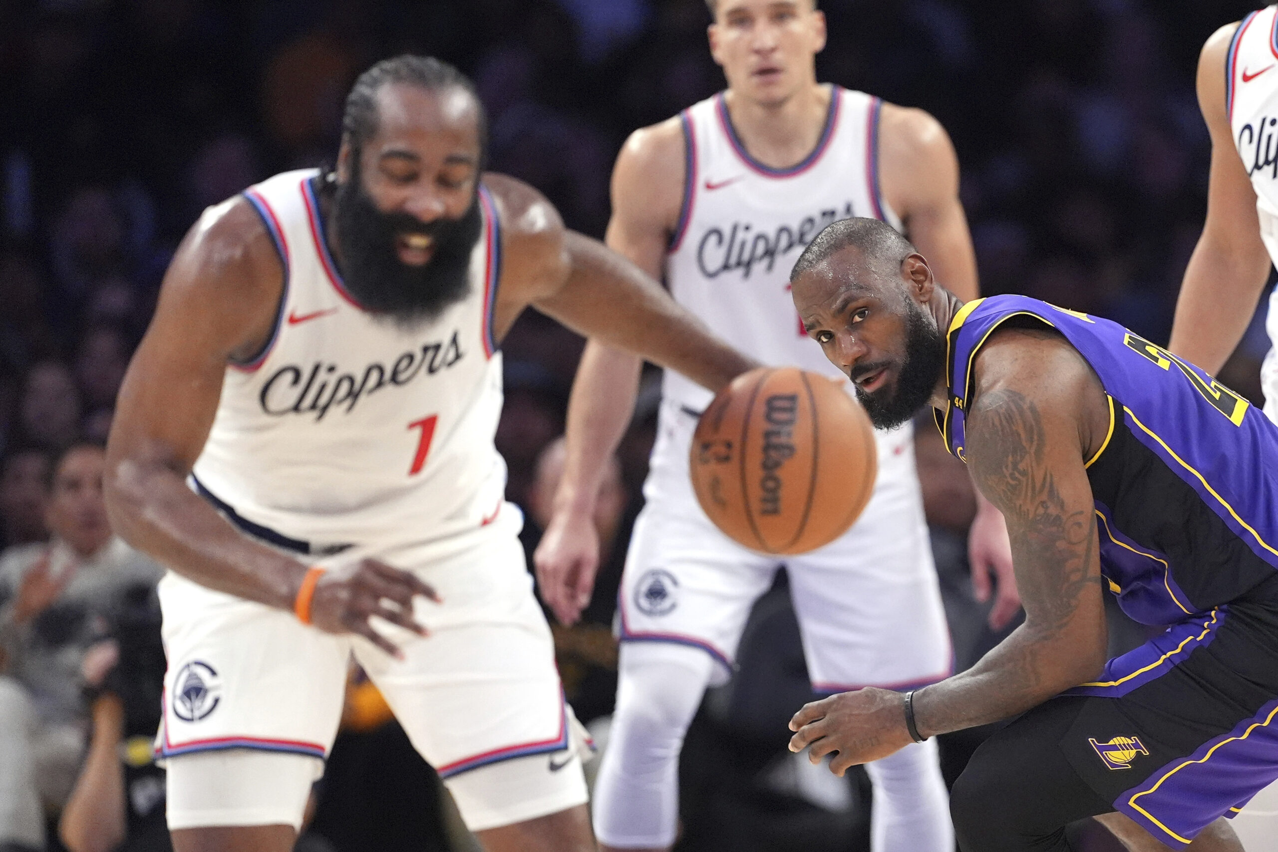 Clippers guard James Harden, left, steals the ball from Lakers...