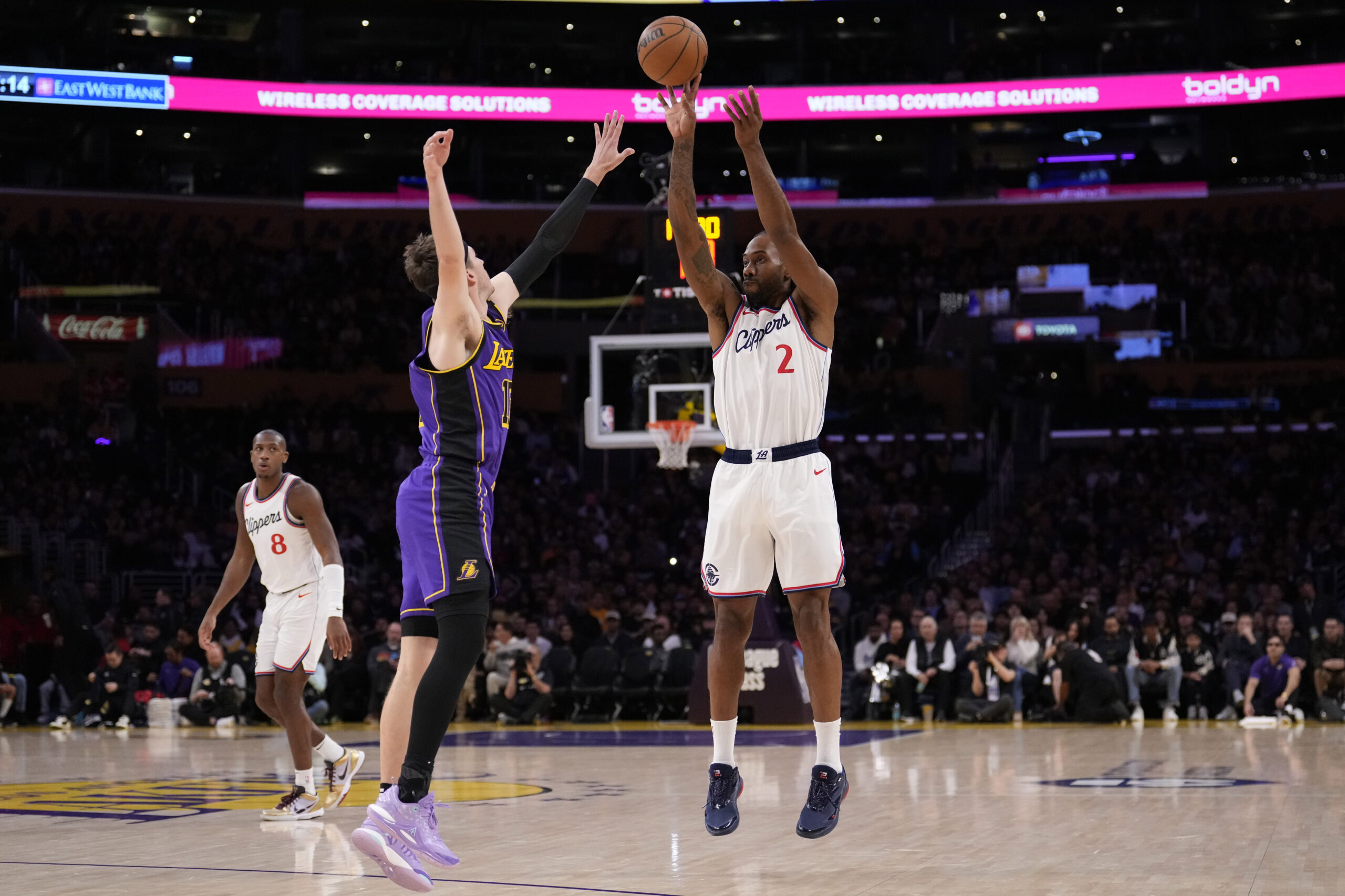 Clippers forward Kawhi Leonard, right, shoots as Lakers guard Austin...