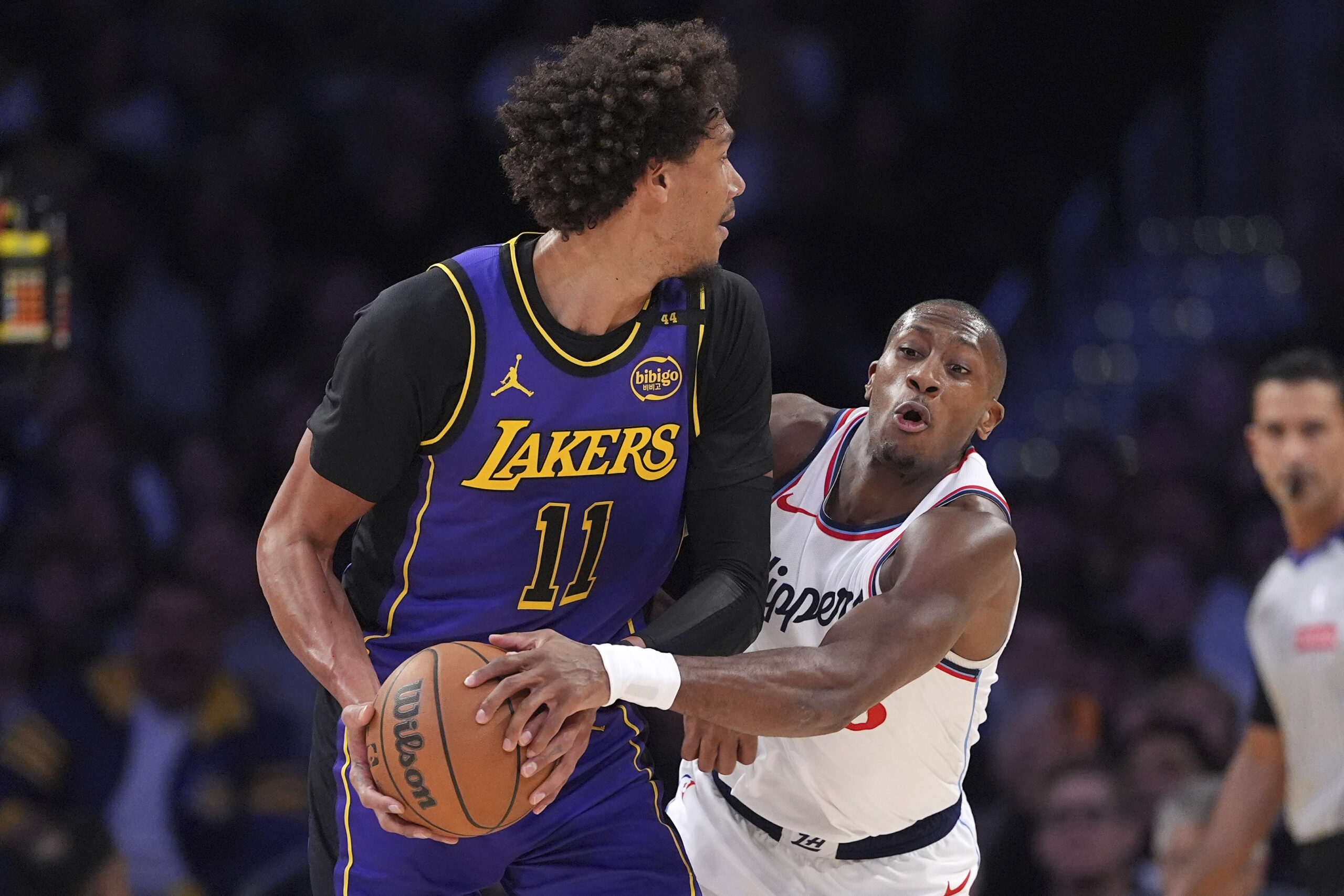 Clippers guard Kris Dunn, right, reaches in and fouls Lakers...