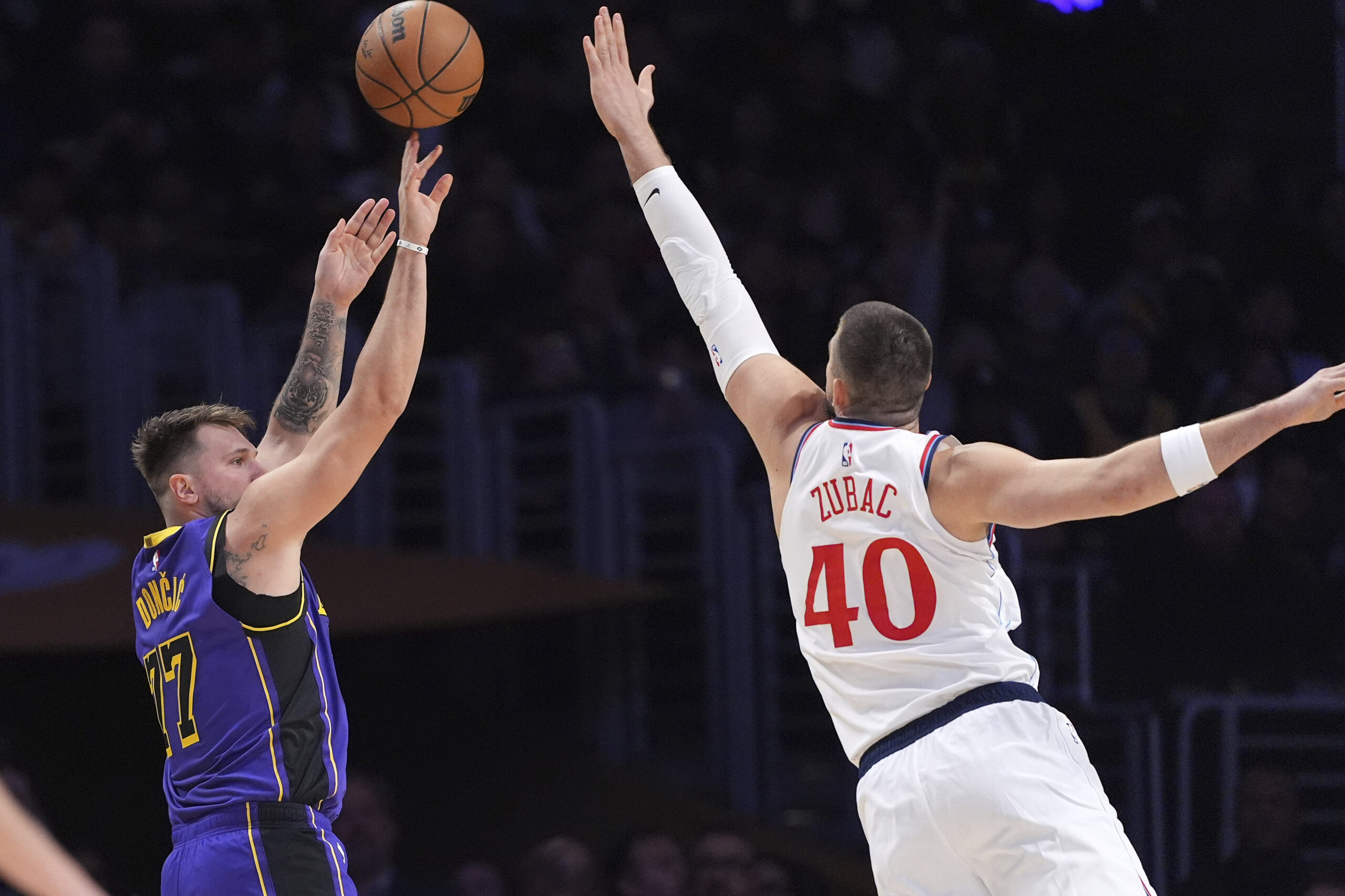 Lakers guard Luka Doncic, left, shoots as Clippers center Ivica...