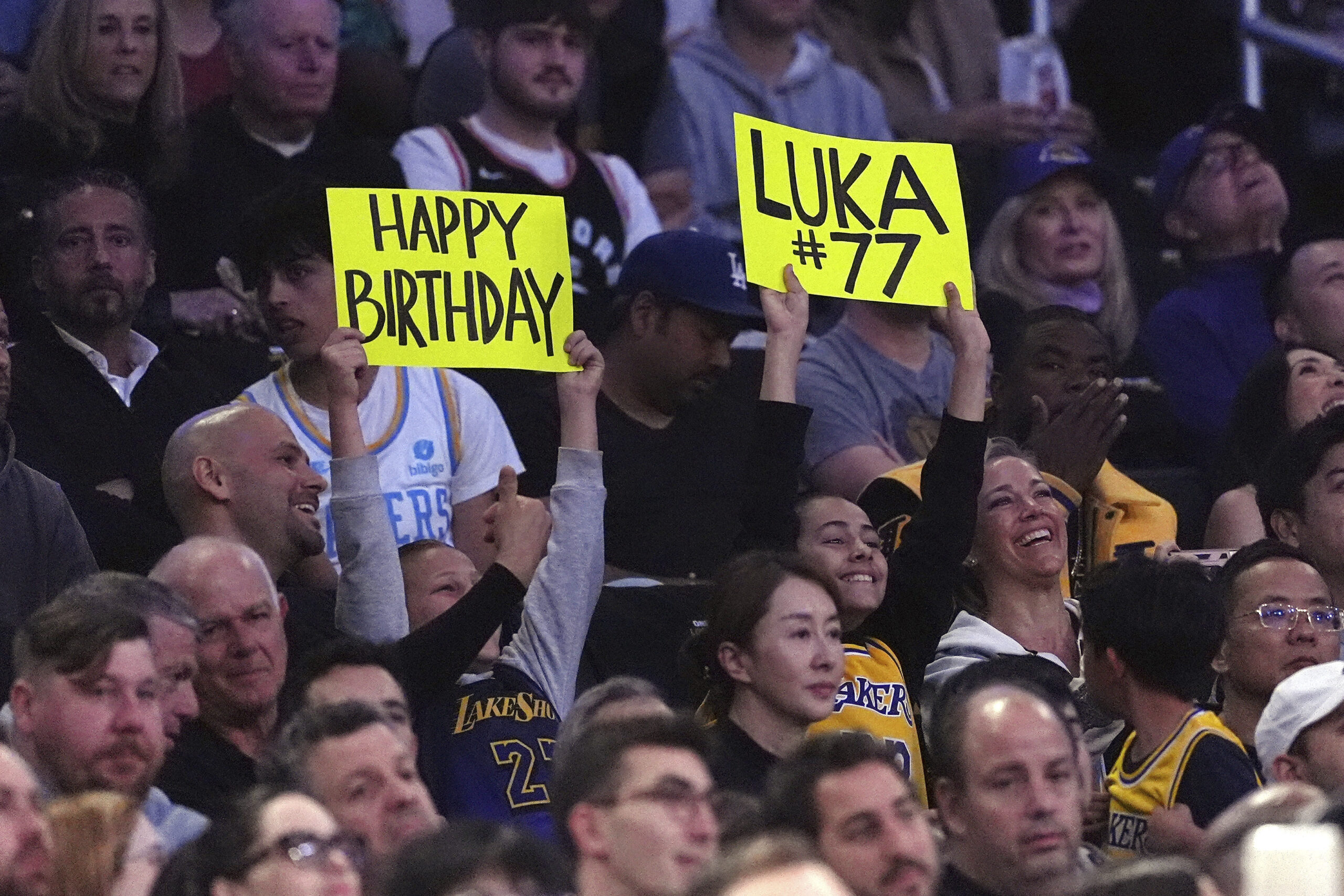 Fans hold up signs for Lakers guard Luka Doncic during...