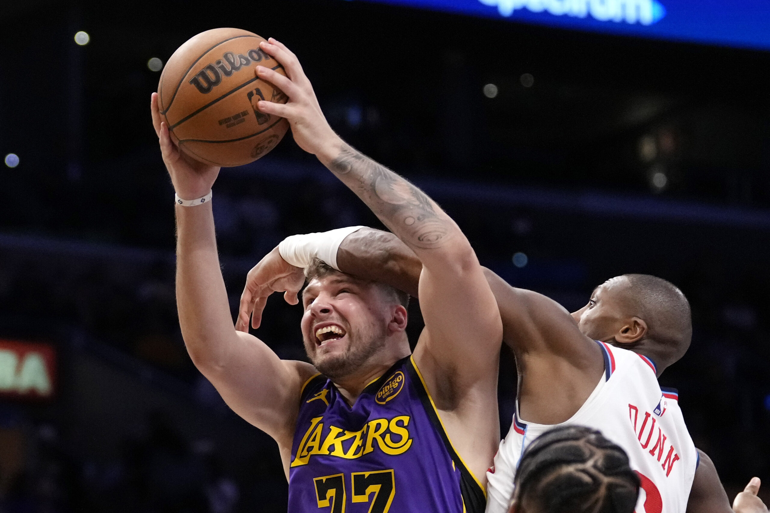 Lakers guard Luka Doncic, left, shoots as Clippers guard Kris...