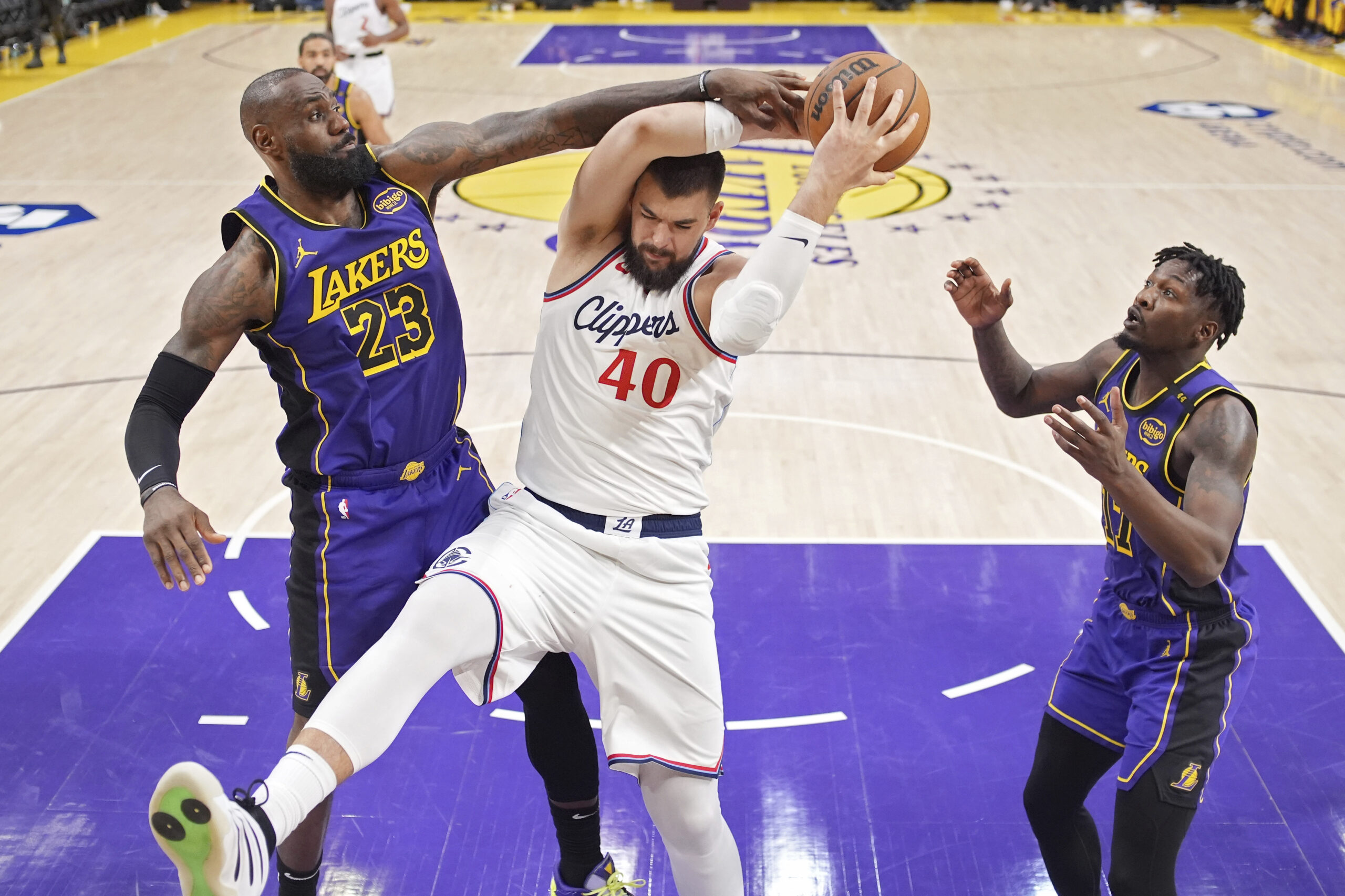 Clippers center Ivica Zubac, center, tries to shoot as Lakers...