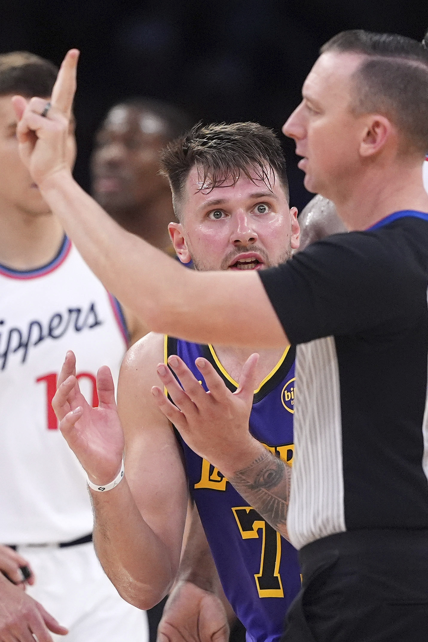 Lakers guard Luka Doncic, center, reacts as he is called...