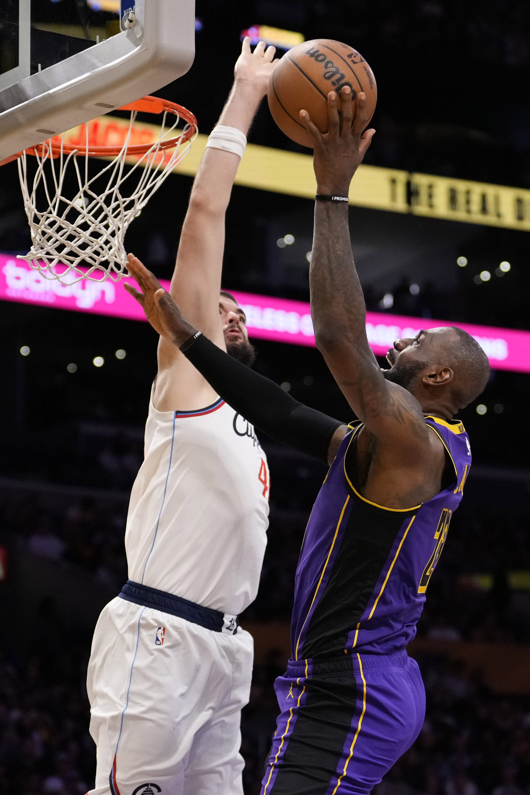 Lakers forward LeBron James, right, shoots as Clippers center Ivica...