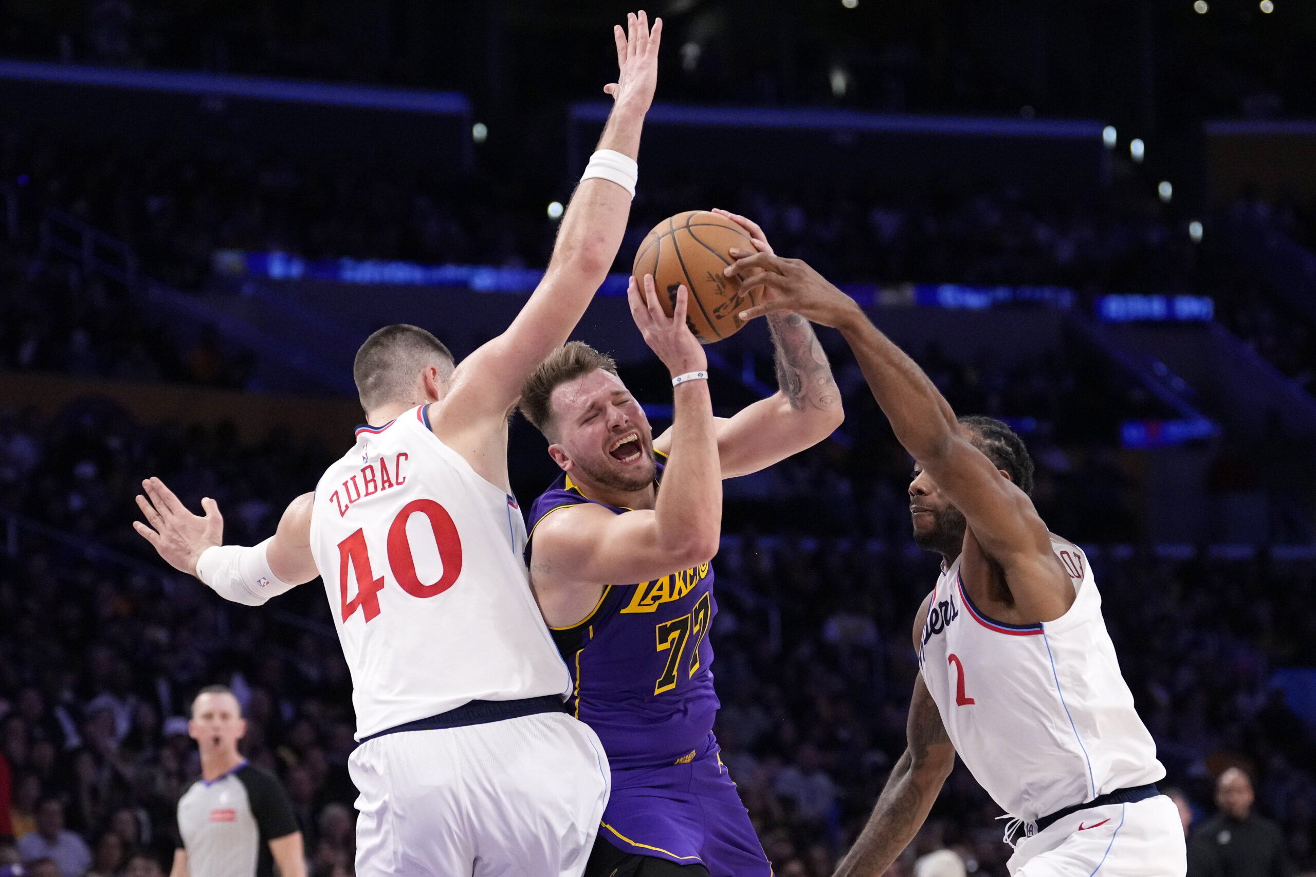 Lakers guard Luka Doncic, center, tries to shoot while under...