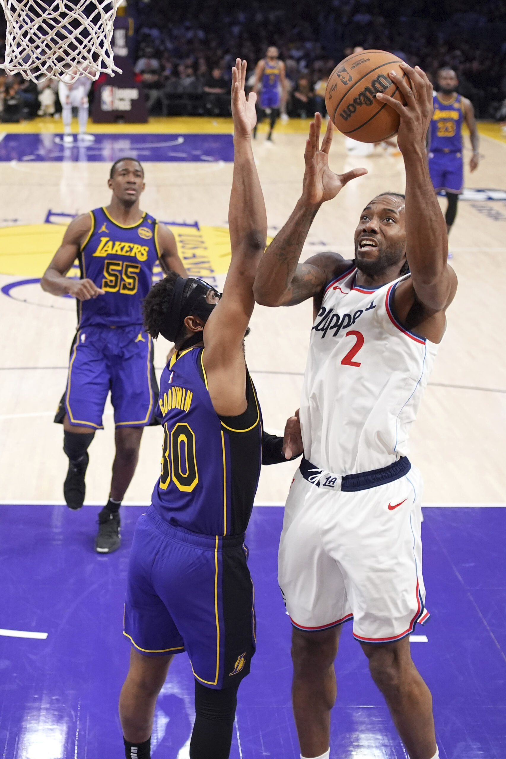 Clippers forward Kawhi Leonard, right, shoots as Lakers guard Jordan...