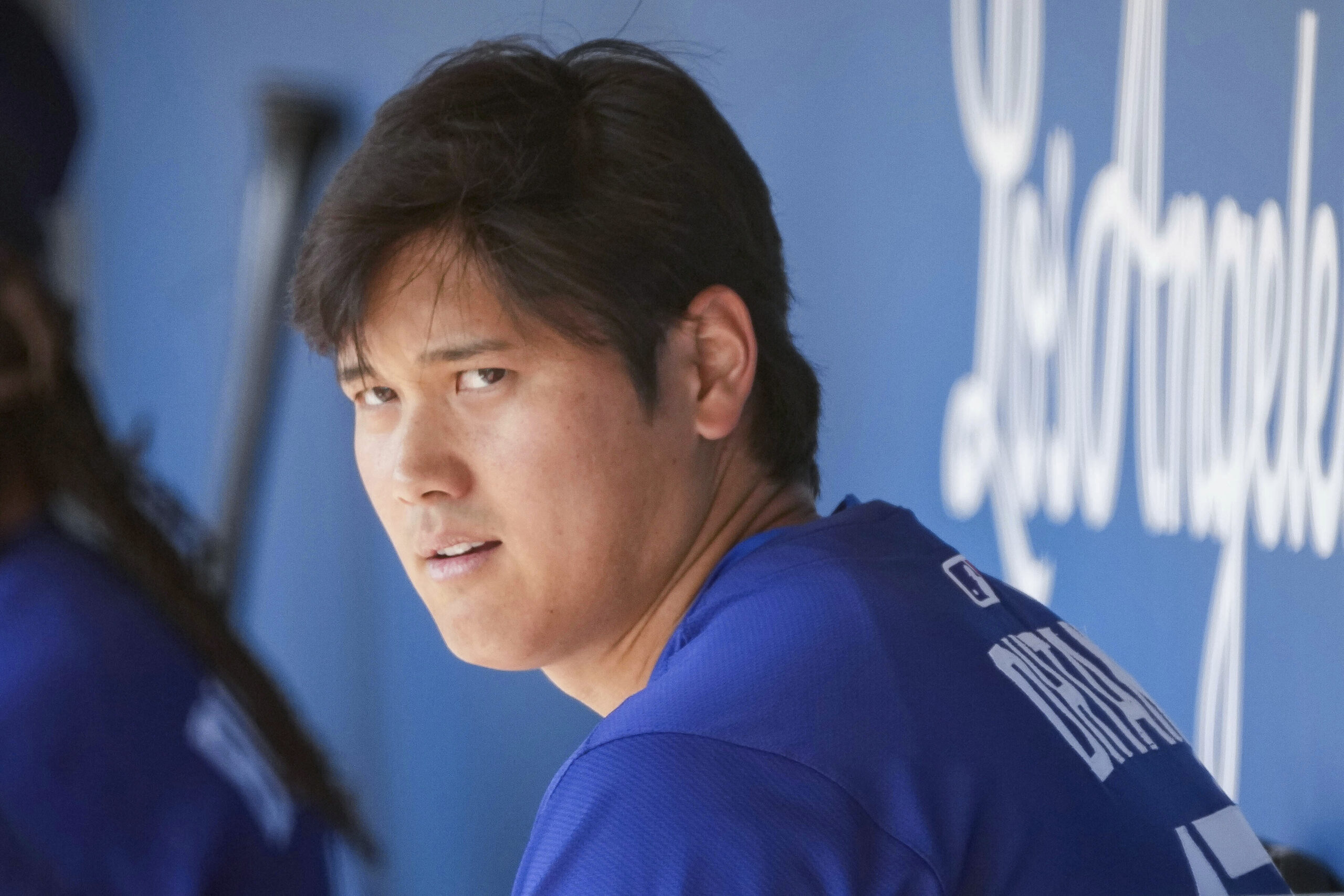 Dodgers two-way player Shohei Ohtani sits in the dugout before...