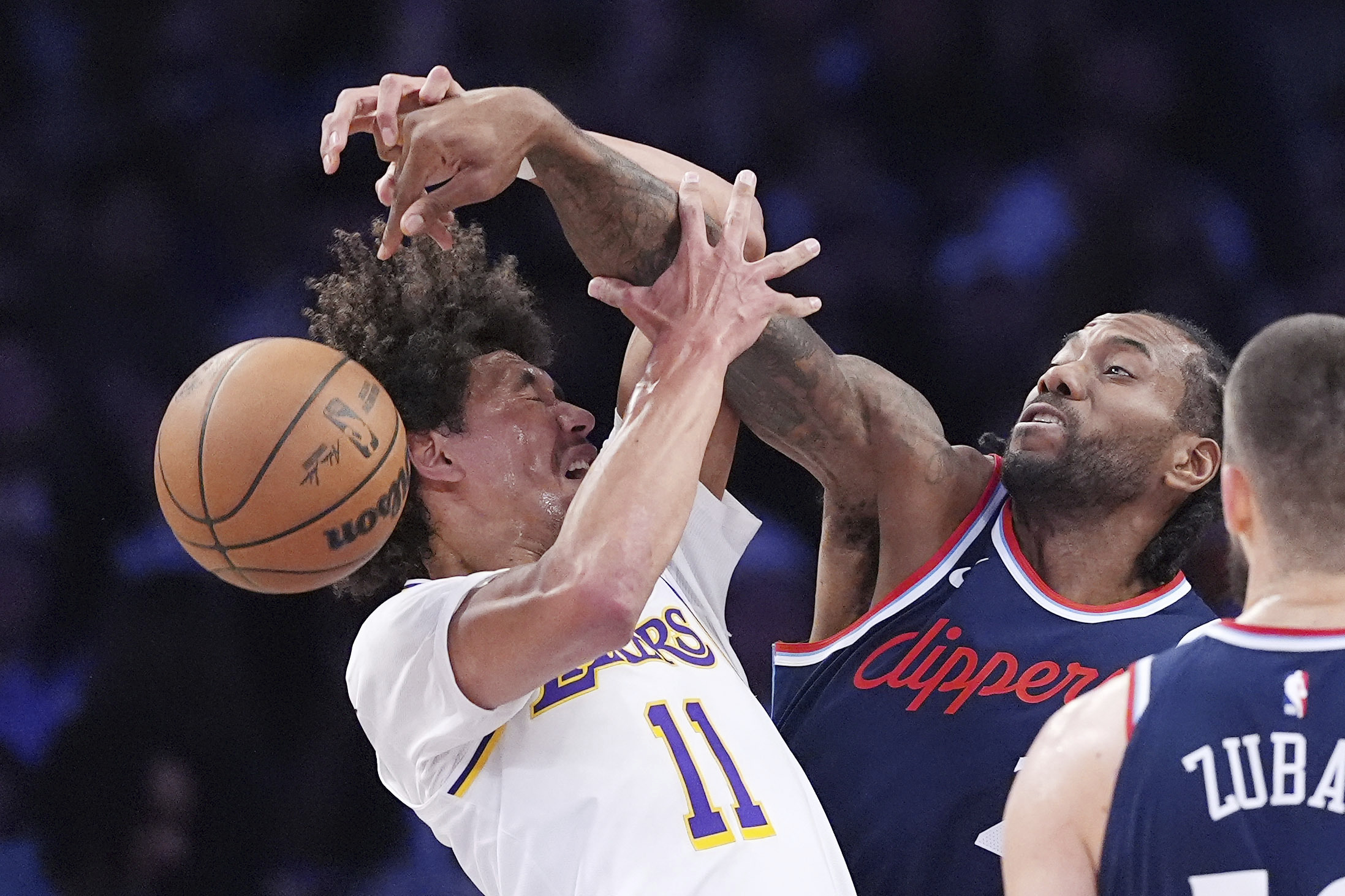 Clippers forward Kawhi Leonard, center, knocks the ball from the...