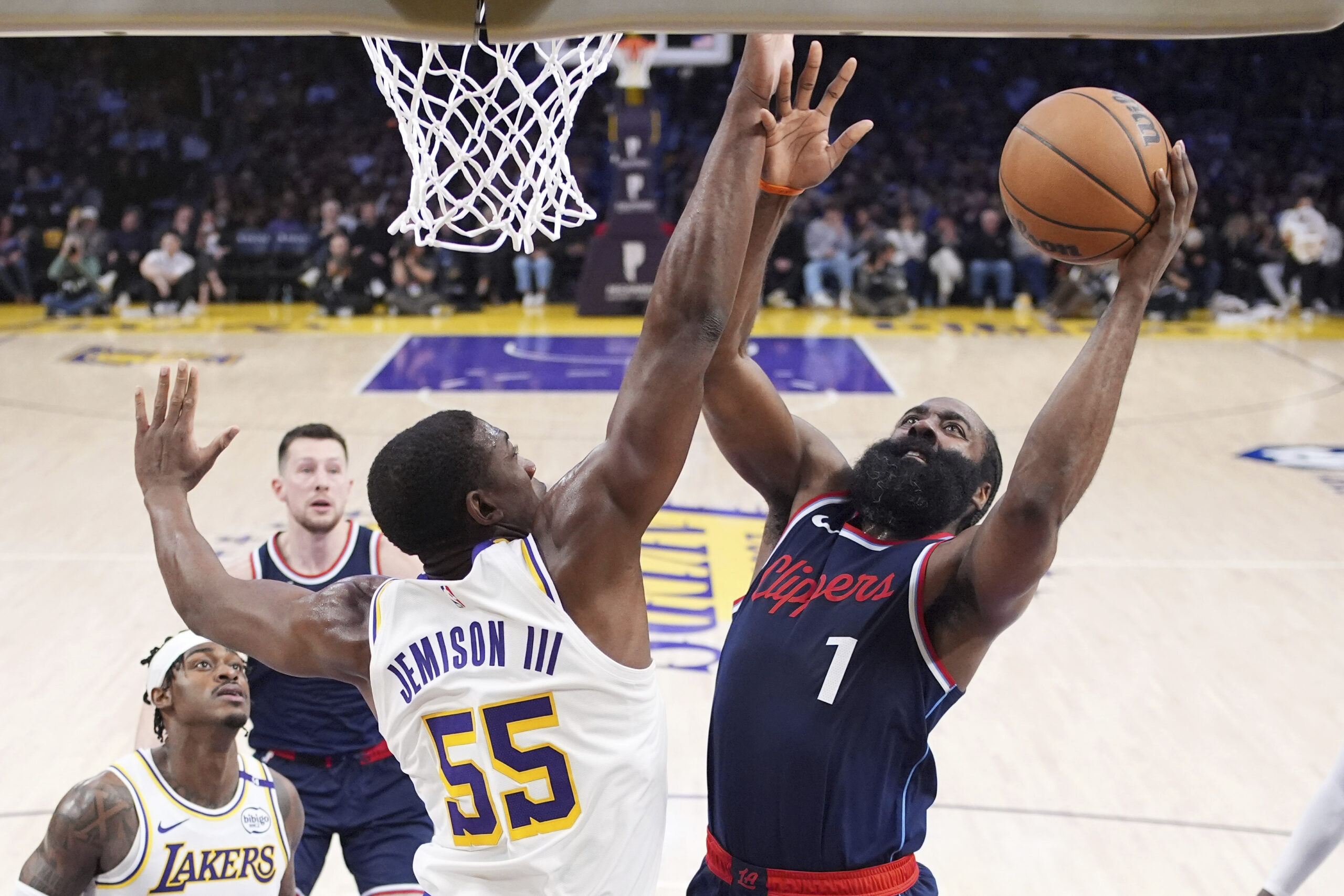 Clippers guard James Harden, right, shoots as Lakers center Trey...