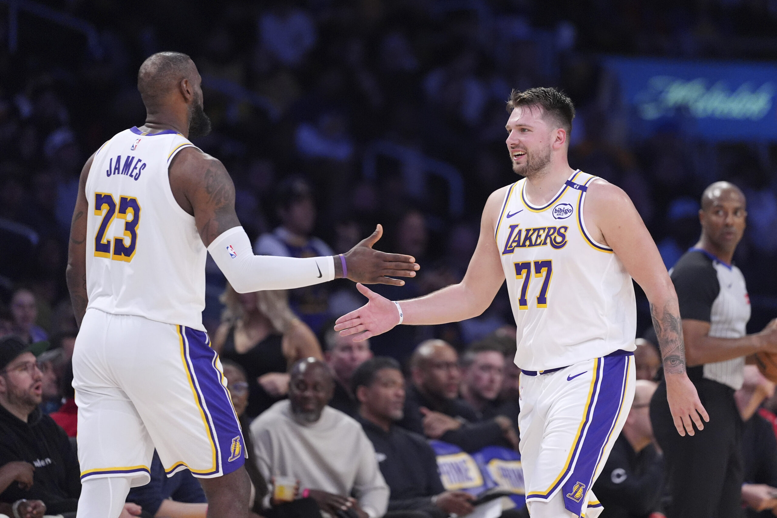 Lakers forward LeBron James, left, and guard Luka Doncic slap...