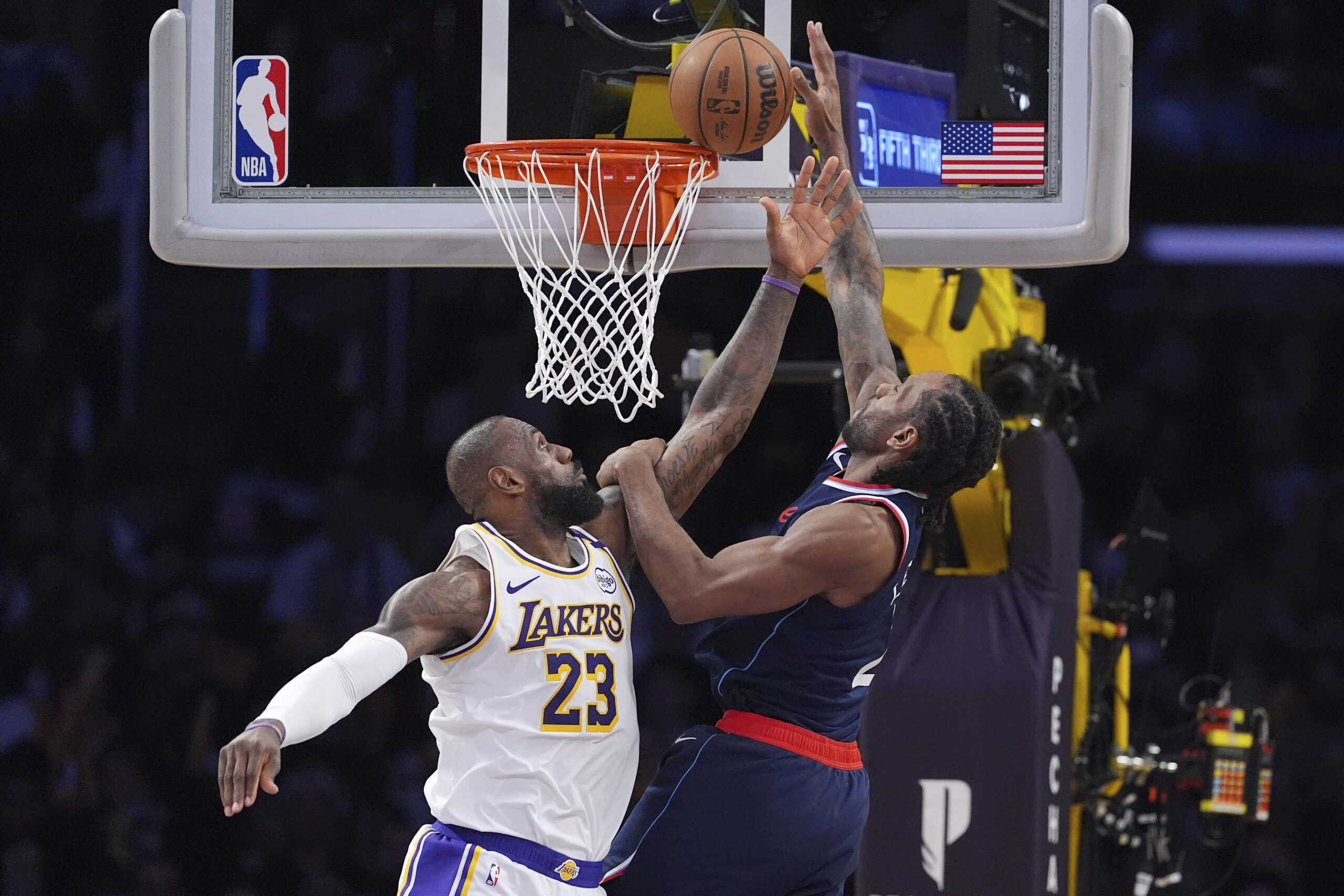 Clippers forward Kawhi Leonard, right, shoots as Lakers forward LeBron...