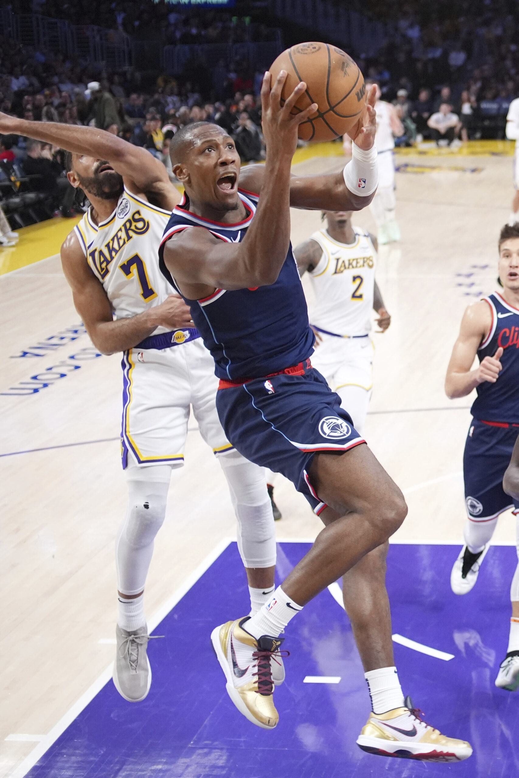 Clippers guard Kris Dunn, right, shoots as Lakers guard Gabe...