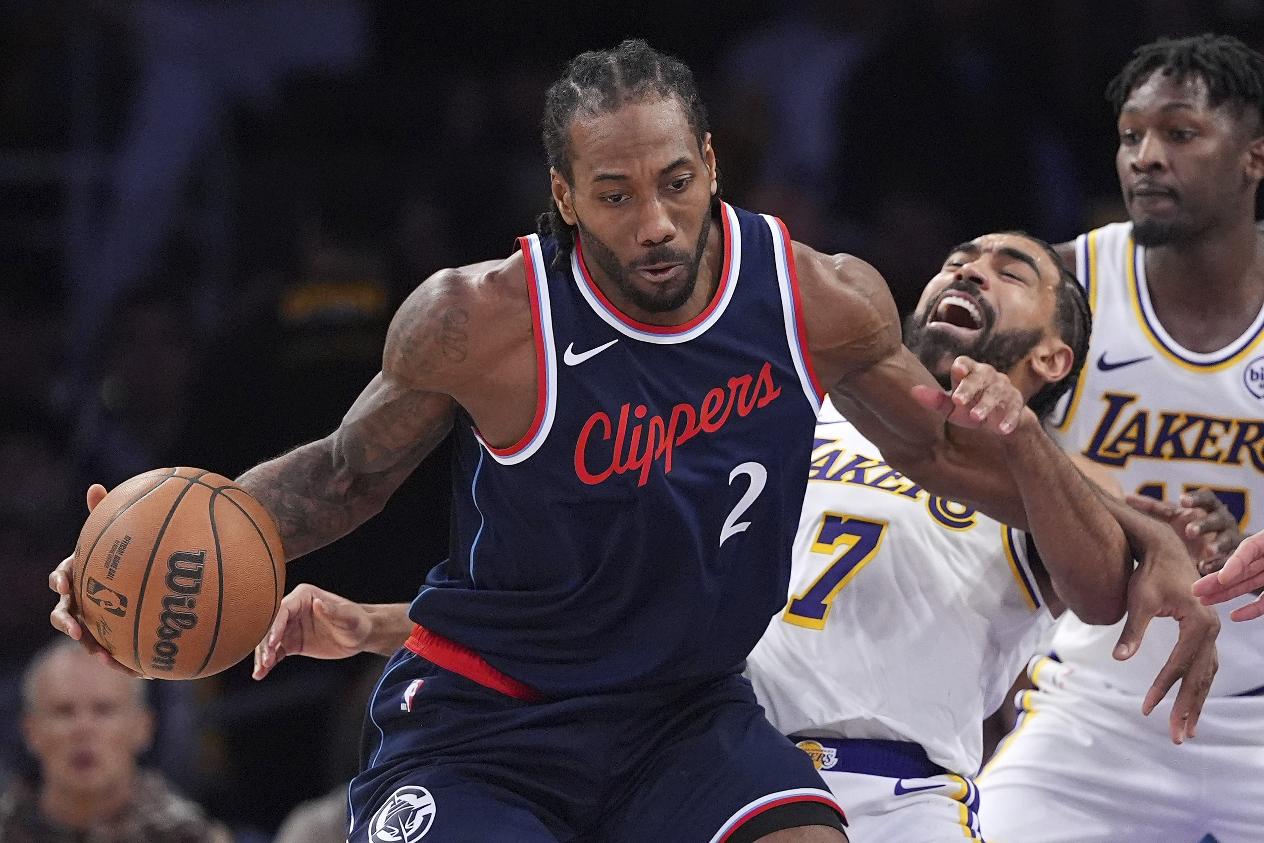 Lakers guard Gabe Vincent, center, falls while trying to guard...