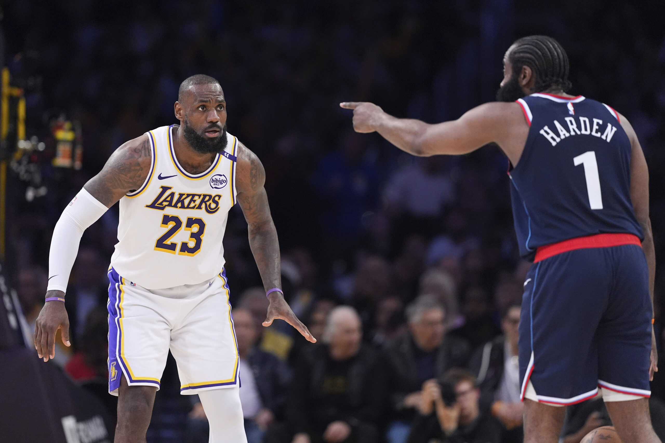 Lakers forward LeBron James, left, watches Clippers guard James Harden...