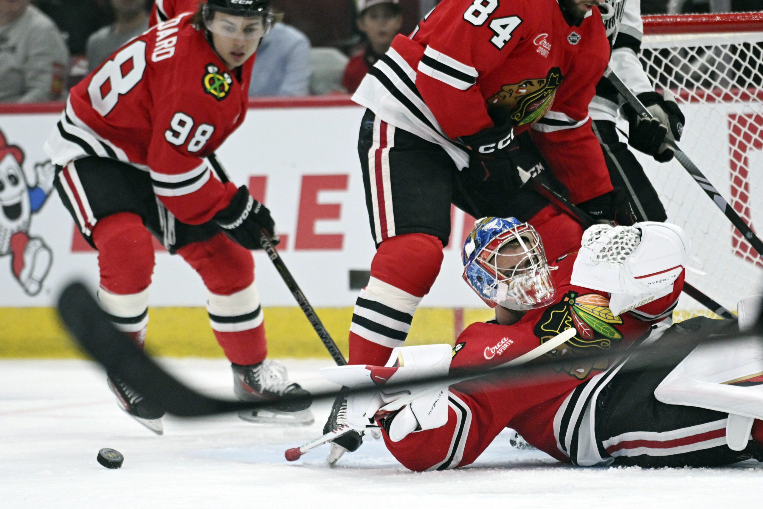 Chicago Blackhawks goalie Spencer Knight, bottom right, makes a save...