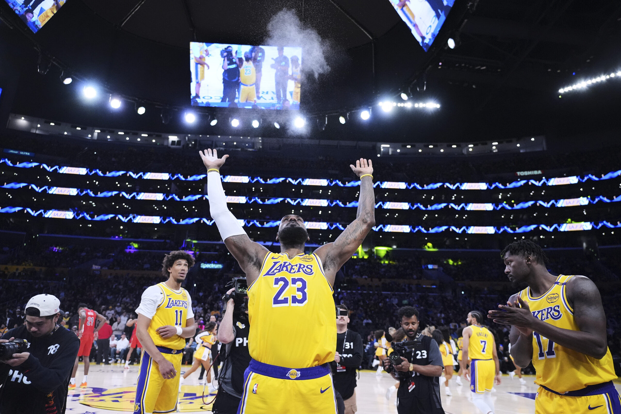 Lakers star LeBron James throws chalk in the air before...