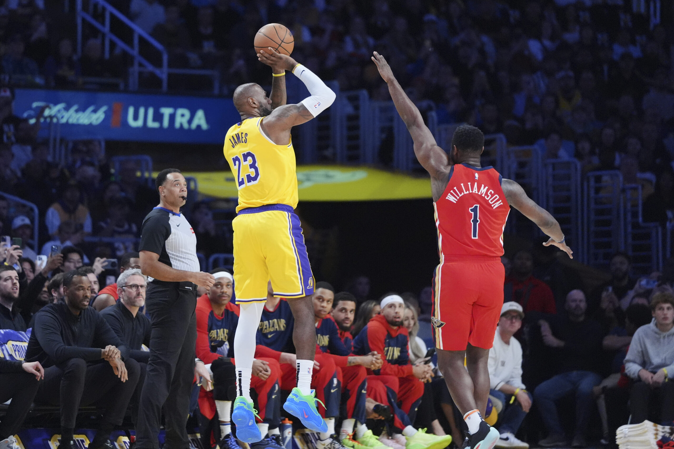 Lakers star LeBron James, left, makes a 3-point shot over...