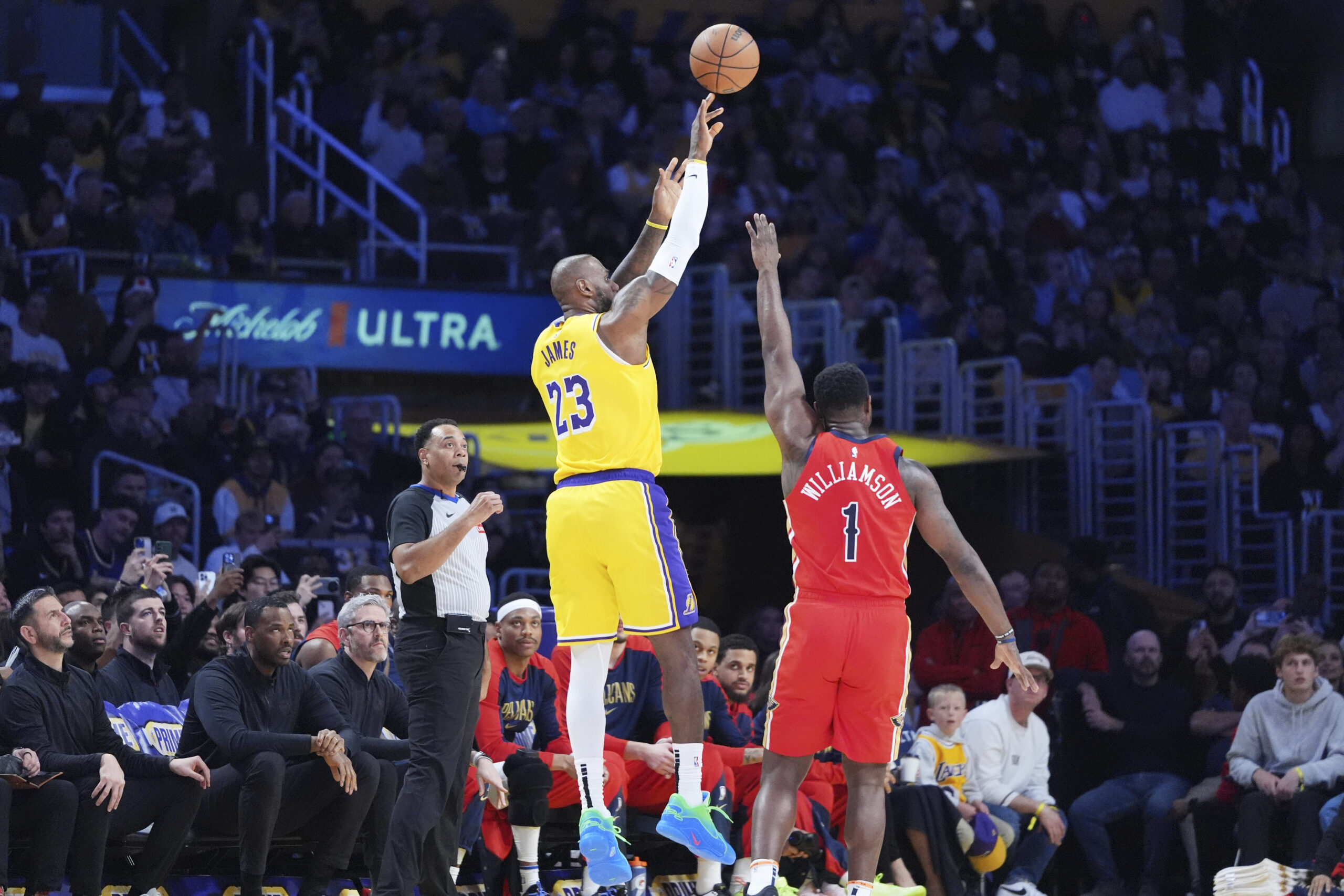 Lakers star LeBron James, left, makes a 3-point shot over...